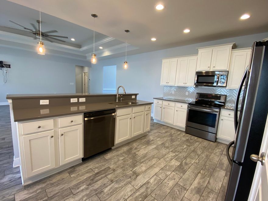 This Home is welcoming you from the etched glass front door to the wide hallway with chair rail, wood-like tile flooring to the 10 feet ceiling accented with recessed lighting & propeller ceiling fan. Kitchen glows with hues of light from farm glass pendant lights over the quarts breakfast bar.  Harborne custom backslash is the perfect accent to the counter tops & white cabinets Be carried away by the aroma of cooking a meal while entertaining in open floor plan. Your laundry room with 2 entries, nestled in-between the bedrooms & Master Suite Makes laundry a breeze.The Master suit is your sanctuary the inverted trey ceiling with its double ceiling fans & accent lighting to the serenity of your garden tub, double vanities, tile shower with bench, dual shower rainheads .....Call today!......