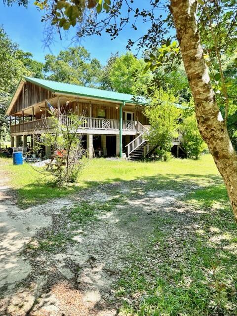 *DIAMOND IN THE ROUGH* Unique home on 4.4 acres. Wrap around porch 8 foot wide surrounds this 2 story dwelling. Main living area on 2nd floor features an open Kitchen/Dining/Living combo. Lots of kitchen cabinets & center island. All appliances in place. Plenty of room for cooking your favorite meals & entertaining. Gas fireplace in living area. Split bedroom floor plan for more privacy. Master bedroom features French doors to the outside. Master bathroom w/ double vanity sinks, Jacuzzi tub, separate shower & walk-in closet. First level is your utility room w/ a window AC unit. Nice size screen room for an additional hang out spot. Home is in need of some TLC so bring your imagination & make this your HOME SWEET HOME today! Lots of potential!