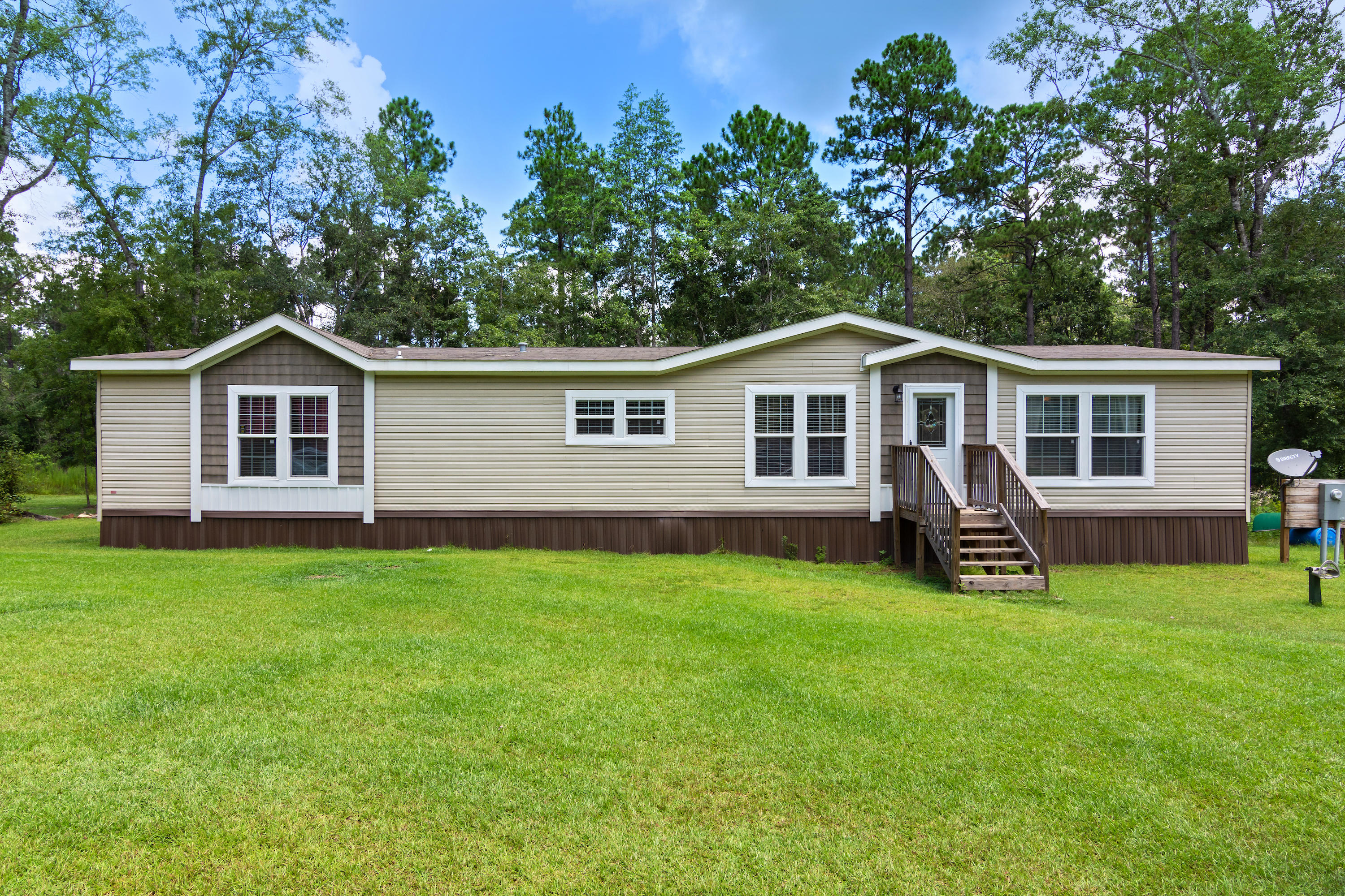 24.87 acres with newer manufactured home and unfinished cottage with carport. This home offers lots of privacy, peace and wildlife. This immaculate 4 bedroom 2 bath home has wood floors in main living area, granite counter tops in kitchen with a large island and an amazing side by side refrigerator/freezer combo. There is also an unfinished 1 bedroom plus bunk room 1 bath cottage perfect for guests or a guest house. You are surrounded by nearly 25 acres of wooded land and mostly surrounded by Blackwater River State Forest. All measurements are approximate, any information deemed important to be verified by buyer.