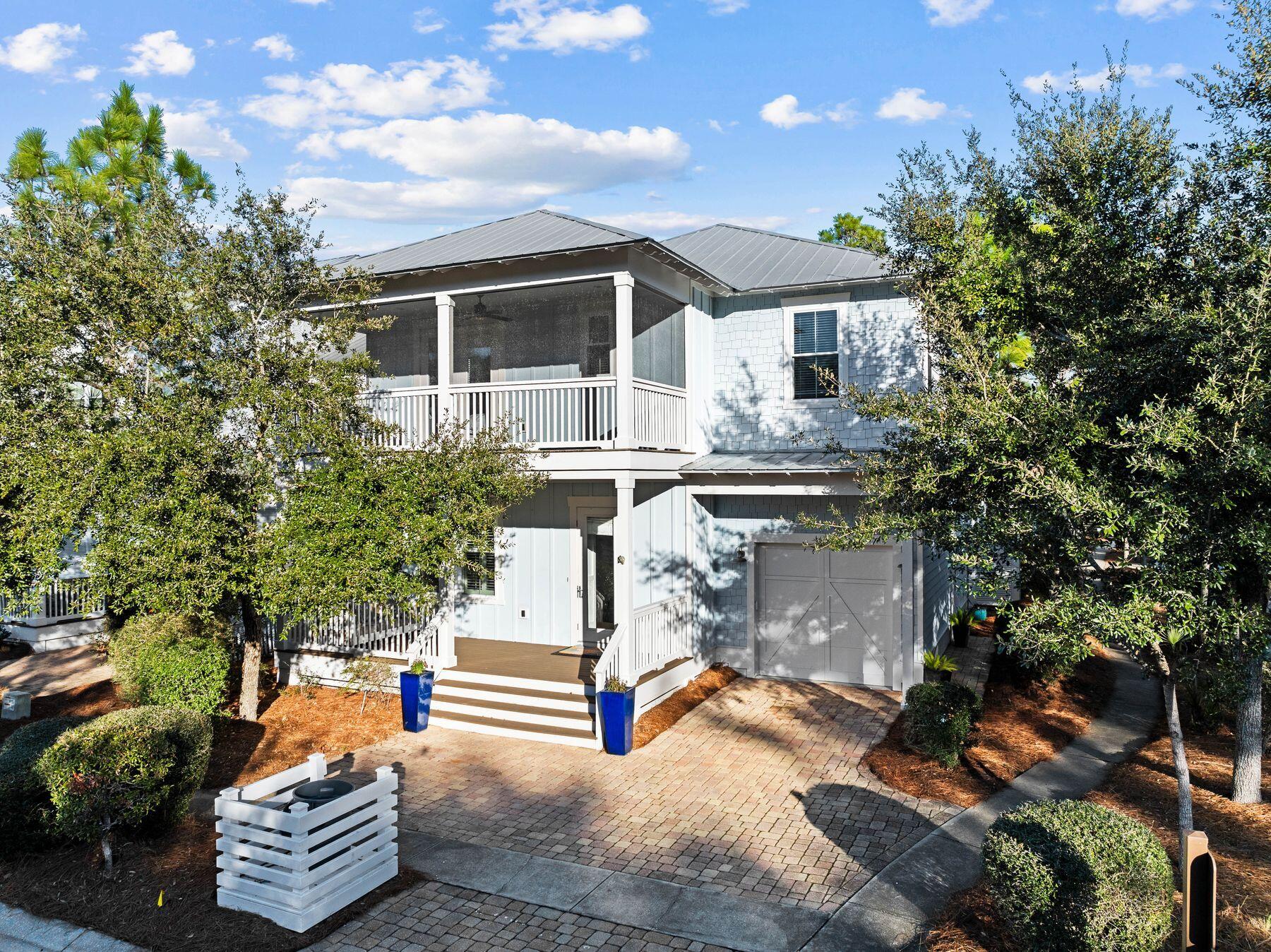 Why choose between nature and beach, when this well-appointed Florida cottage offers both? Located near the entrance to the highly desirable NatureWalk neighborhood, this splendid home is just a mile from the beach along a scenic walking trail. The brick driveway leads to a one-car garage and welcoming front porch. Built in classical style, the entrance foyer opens to a formal dining room, boasting a noteworthy coffered ceiling and wainscot walls. The adjoining walk-through butler's pantry includes a wet bar with a built-in wine refrigerator, making this room perfect for entertaining. Solid hardwood flooring continues past a laundry room (one of two) and a powder room to the open great room. The chef's kitchen is oversized with a Quartz-topped island that incorporates a walk-in wine rack and open shelf ends. Bar stools invite family and friends to linger and chat over breakfast pancakes or evening cocktails. A glass tile backsplash, stainless steel appliances, and a chimney hood over the gas cooktop complement a full range of high-quality cabinets. There's a convenient dining table in the breakfast nook. The fireplace provides a natural focal point for putting your feet up and watching TV in the sitting area. Everyday living outdoors continues with a beautiful bed swing on rear covered porch. The generous first-floor owner's suite offers all the convenience of living on one level if desired. A glass door leads directly to the rear porch offering views of the rear yard with mature trees casting dappled shade. The fully tiled master bathroom is sleek and spacious with a twin vanity, deep tub and a walk-in shower. Another door leads into the walk-in closet. Retire upstairs to find a versatile open loft space suitable for a media, office or game room, or use it as an extra sleep space with lots of storage. It includes a built-in coffee bar with a refrigerator for guests to grab a cup of coffee or chilled beverages 24/7. A 2nd master suite is located upstairs with double sinks along with two more swanky suites that each have their own private bathroom and large closet. The upper balcony is screened, making it a peaceful retreat for reading and relaxing as the sun sets on another perfect day. This floor plan with over 3000 square feet is a rare find in Naturewalk. The surrounding community has endless amenities, including a playground, heated lap pool, zero-entry pool, hot tub, fire pit, grills, sports TV and bar area for parties at The Gathering Place. Elsewhere, there are fitness stations, tennis/ pickleball courts and walking trails. Nearby, Point Washington State Forest offers more recreational opportunities. For those looking for rental income, this well-located home is projected to bring in a strong in annual income, making it a smart buy for any investor.