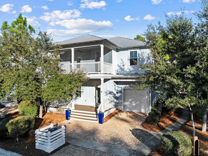Why choose between nature and beach, when this well-appointed Florida cottage offers both? Located near the entrance to the highly desirable NatureWalk neighborhood, this splendid home is just a mile from the beach along a scenic walking trail. The brick driveway leads to a one-car garage and welcoming front porch. Built in classical style, the entrance foyer opens to a formal dining room, boasting a noteworthy coffered ceiling and wainscot walls. The adjoining walk-through butler's pantry includes a wet bar with a built-in wine refrigerator, making this room perfect for entertaining. Solid hardwood flooring continues past a laundry room (one of two) and a powder room to the open great room. The chef's kitchen is oversized with a Quartz-topped island that incorporates a walk-in wine rack and open shelf ends. Bar stools invite family and friends to linger and chat over breakfast pancakes or evening cocktails. A glass tile backsplash, stainless steel appliances, and a chimney hood over the gas cooktop complement a full range of high-quality cabinets. There's a convenient dining table in the breakfast nook. The fireplace provides a natural focal point for putting your feet up and watching TV in the sitting area. Everyday living outdoors continues with a beautiful bed swing on rear covered porch. The generous first-floor owner's suite offers all the convenience of living on one level if desired. A glass door leads directly to the rear porch offering views of the rear yard with mature trees casting dappled shade. The fully tiled master bathroom is sleek and spacious with a twin vanity, deep tub and a walk-in shower. Another door leads into the walk-in closet. Retire upstairs to find a versatile open loft space suitable for a media, office or game room, or use it as an extra sleep space with lots of storage. It includes a built-in coffee bar with a refrigerator for guests to grab a cup of coffee or chilled beverages 24/7. A 2nd master suite is located upstairs with double sinks along with two more swanky suites that each have their own private bathroom and large closet.  The upper balcony is screened, making it a peaceful retreat for reading and relaxing as the sun sets on another perfect day. This floor plan with over 3000 square feet is a rare find in Naturewalk.  The surrounding community has endless amenities, including a playground, heated lap pool, zero-entry pool, hot tub, fire pit, grills, sports TV and bar area for parties at The Gathering Place. Elsewhere, there are fitness stations, tennis/ pickleball courts and walking trails. Nearby, Point Washington State Forest offers more recreational opportunities. For those looking for rental income, this well-located home is projected to bring in a strong in annual income, making it a smart buy for any investor.