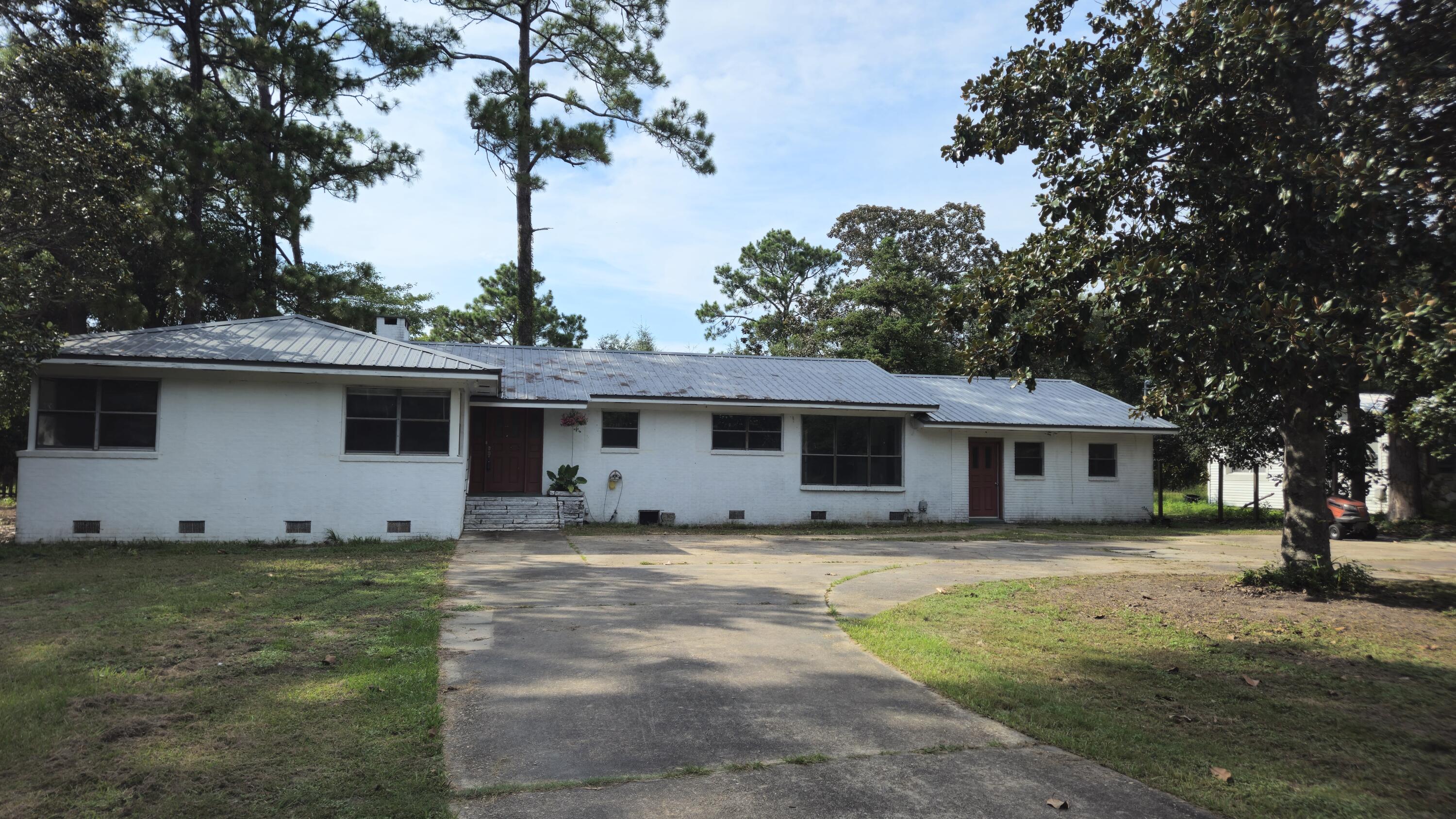 This hidden home, on 2 acres of lakefront land, offers a rare opportunity to finish a dream renovation. With its own private dock on Lake Stanley, a nearby public park, and direct access to Hwy 90 and I-10, this location combines quiet lakeside living with convenience to the Emerald Coast. The 8-car driveway is perfect for hosting or storying toys. Updates already done include- brand new appliances installed in the open-concept kitchen, and fresh LVP flooring runs through the main living areas. The home also features an added Florida room, walk-in pantry, laundry room addition, plus a bonus space ready for your vision. The roof is just 5 years old. This home provides a canvas for buyers to finish the perfect lakefront retreat!