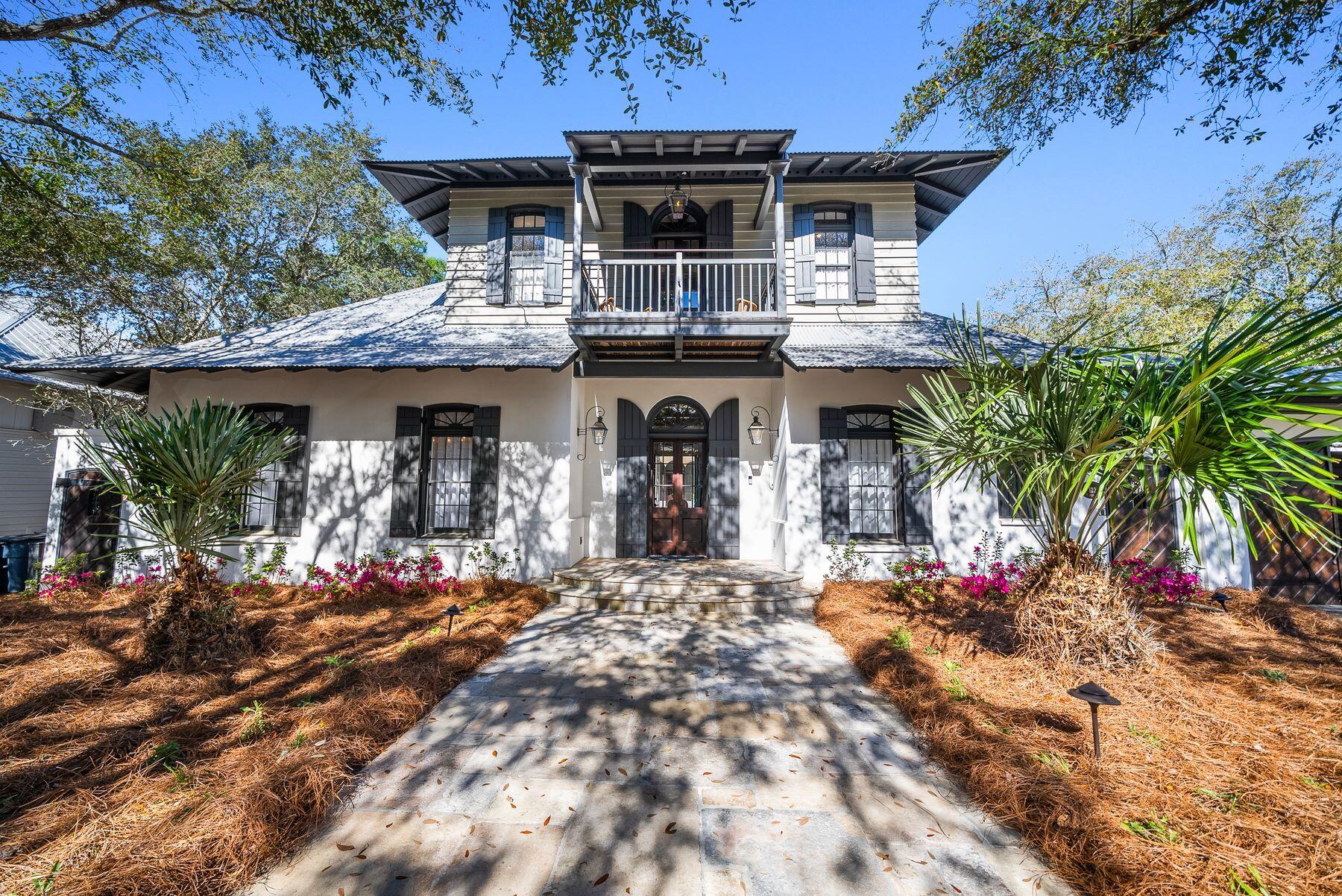 Tucked behind solid wood gates and backing onto lush green space, this stately estate home in Rosemary Beach offers a rare combination of privacy, sophistication and spacious living. Designed by Charrette Design Group, the residence is a masterpiece of architectural craftsmanship, featuring a main home with beautifully curated interiors and a separate three-story guest house that provides ample accommodations for extended family, guests or rental opportunities. The expansive property is one of the largest and most private in Rosemary Beach, with an enclosed courtyard that serves as the heart of the home, seamlessly connecting multiple entertainment spaces and providing direct views of the pool from nearly every room. Refined details elevate the interiors, from the grand foyer with soaring ceilings to the antique French limestone flooring that transitions into rich hardwoods. The open living area, framed by exposed beams, features an Isokern fireplace with a custom mantel, offering a warm and inviting atmosphere. A state-of-the-art kitchen is designed for both casual gatherings and gourmet meals, complete with a center island, breakfast bar and top-tier appliances. The formal dining room exudes historic charm, with dark wood accents and a medieval-style chandelier enhancing the character of the space. The primary suite, located in its own wing, serves as a private sanctuary with a sunlit sitting area, an elegant ensuite bath and a secluded balcony. The guest house mirrors the thoughtful design of the main home, featuring its own full kitchen, living space, laundry and a second-floor bedroom and bunk room accessed by a spiral staircase. Outside, the serene courtyard offers a stunning backdrop for entertaining, featuring an L-shaped black-bottom pool, a tranquil water feature and a gas/wood-burning fireplace. A wraparound porch provides an inviting space for al fresco dining and relaxation year-round. Located in the highly sought-after Rosemary Beach community, this home offers access to a private beach, multiple pools, a fitness center and a vibrant town center filled with upscale shopping and fine dining. Whether as a primary residence, a second home or an investment opportunity, this exceptional property captures the essence of luxury coastal living.