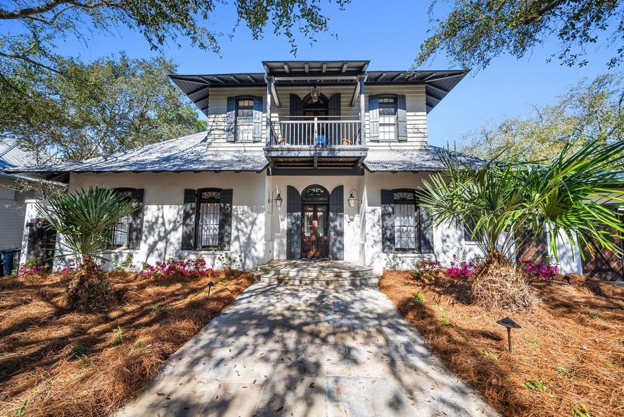 Tucked behind solid wood gates and backing onto lush green space, this stately estate home in Rosemary Beach offers a rare combination of privacy, sophistication and spacious living. Designed by Charrette Design Group, the residence is a masterpiece of architectural craftsmanship, featuring a main home with beautifully curated interiors and a separate three-story guest house that provides ample accommodations for extended family, guests or rental opportunities. The expansive property is one of the largest and most private in Rosemary Beach, with an enclosed courtyard that serves as the heart of the home, seamlessly connecting multiple entertainment spaces and providing direct views of the pool from nearly every room. Refined details elevate the interiors, from the grand foyer with soaring ceilings to the antique French limestone flooring that transitions into rich hardwoods. The open living area, framed by exposed beams, features an Isokern fireplace with a custom mantel, offering a warm and inviting atmosphere. A state-of-the-art kitchen is designed for both casual gatherings and gourmet meals, complete with a center island, breakfast bar and top-tier appliances. The formal dining room exudes historic charm, with dark wood accents and a medieval-style chandelier enhancing the character of the space. The primary suite, located in its own wing, serves as a private sanctuary with a sunlit sitting area, an elegant ensuite bath and a secluded balcony. The guest house mirrors the thoughtful design of the main home, featuring its own full kitchen, living space, laundry and a second-floor bedroom and bunk room accessed by a spiral staircase. Outside, the serene courtyard offers a stunning backdrop for entertaining, featuring an L-shaped black-bottom pool, a tranquil water feature and a gas/wood-burning fireplace. A wraparound porch provides an inviting space for al fresco dining and relaxation year-round. Located in the highly sought-after Rosemary Beach community, this home offers access to a private beach, multiple pools, a fitness center and a vibrant town center filled with upscale shopping and fine dining. Whether as a primary residence, a second home or an investment opportunity, this exceptional property captures the essence of luxury coastal living.