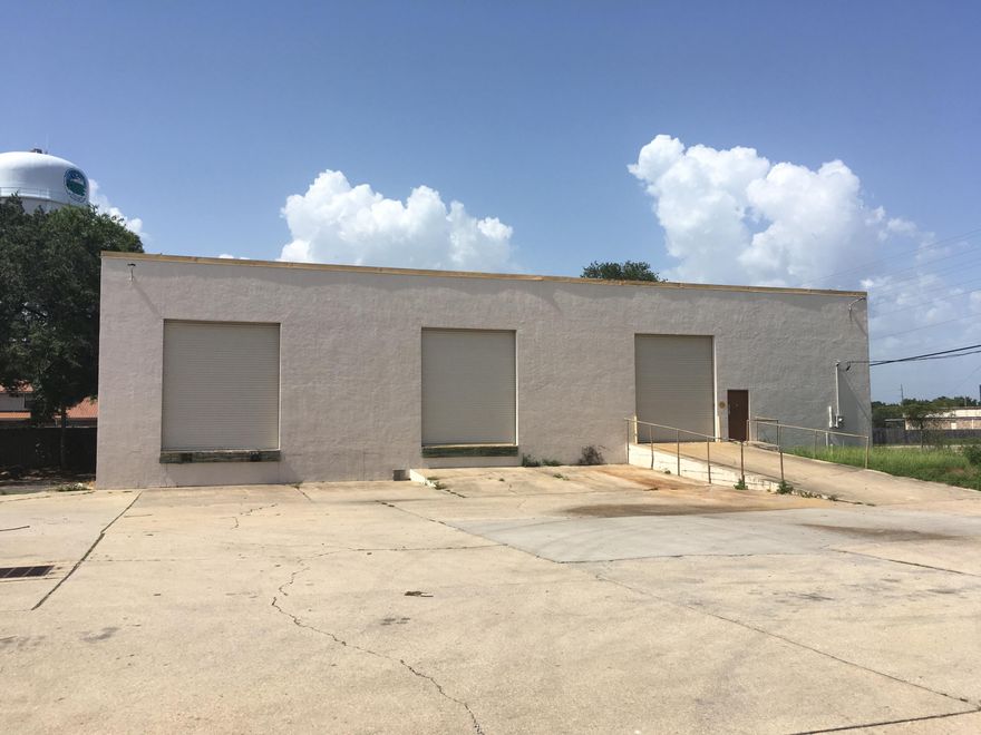 Concrete block warehouse with loading docks and bathroom.