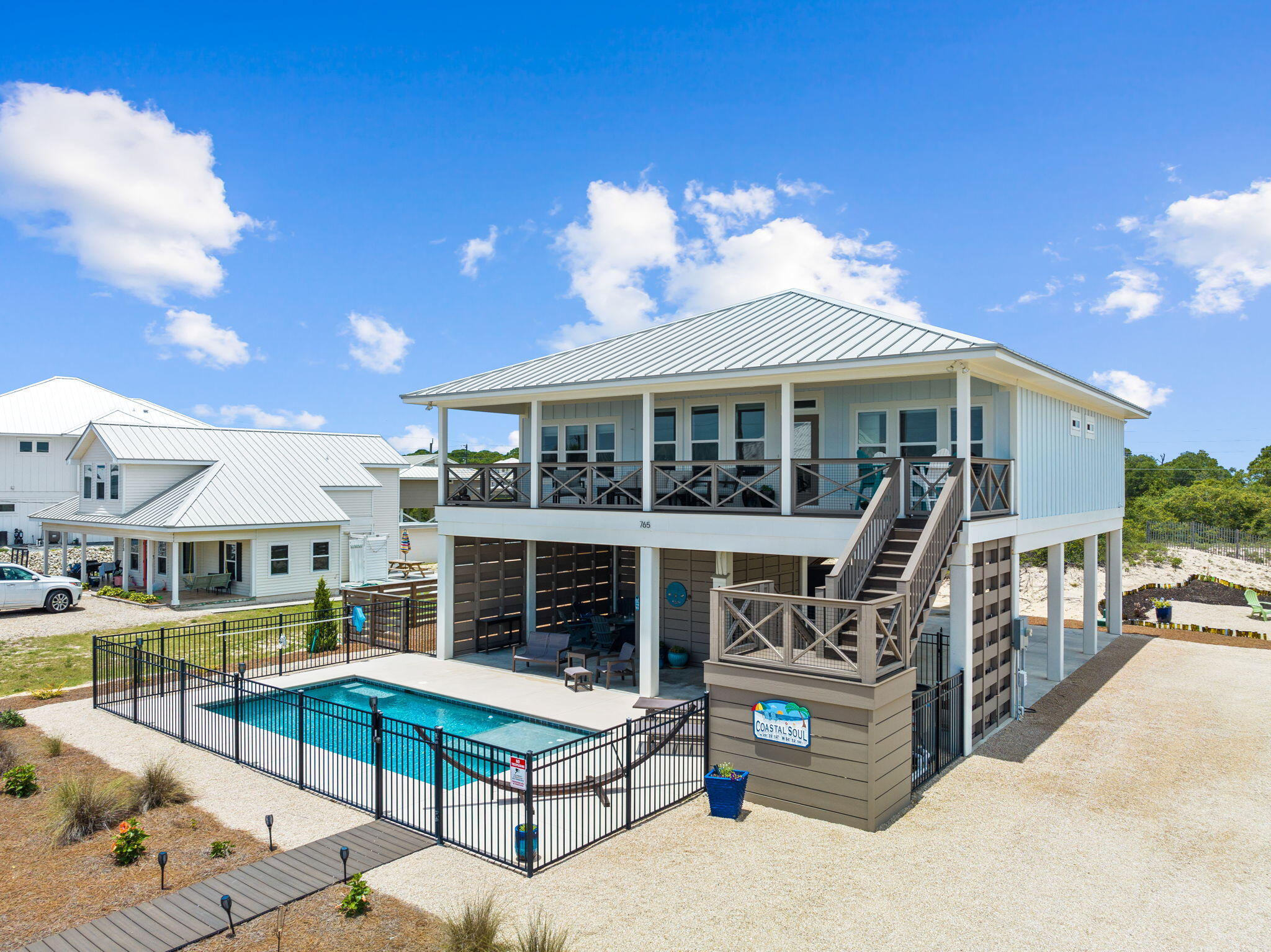 This is a must-see 1st tier house on St. George Island with forever Gulf views and deeded beach access just steps from the heated/chilled pool. Completed in 2019, this like-new 4 bedroom / 4 bathroom beach house has never been rented and includes all the features and luxuries you would want if using it for your personal get away. Those features include propane gas range and tankless water heater, high end appliances, lush landscaping, Trex decking, outdoor fire pit, pool front entertainment area, and LVT and tile flooring throughout. The beach butler lift makes it easy to stock the house with groceries or bring up luggage. While the house design and finishes are amazing, what makes this house unique is its endless Gulf views and beach access.