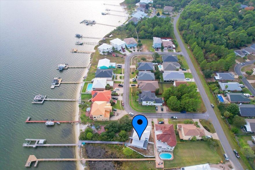 Waterfront Custom Home with Boat Dock and TWO Boat Slips/Lifts in the Sparkling Waters Neighborhood. Incredible unobstructed Sound and Gulf Views from the balconies and interior. Light and Airy Coastal Vibes fill this modern home.  Open Living Concept, two sided clear Gas Fireplace in living and dining room, Crown Molding, Remote and Manual Sun Filtering Blinds, Granite in kitchen, Stainless Steel Appliances, Master Suite features a Whirlpool Tub with Large Walk In Shower, Two Bedrooms share a Jack & Jill Bathroom, Office with Murphy Bed, Bedroom #3 has Murphy Bed, Tile and Luxury Vinyl flooring,  Vinyl Fenced yard, Cobble Stone Driveway, Garage with raised Workshop.  So many Upgrades and Special features in this home!  Neighborhood has a charming white sandy Beach with Dock and Gazebo.