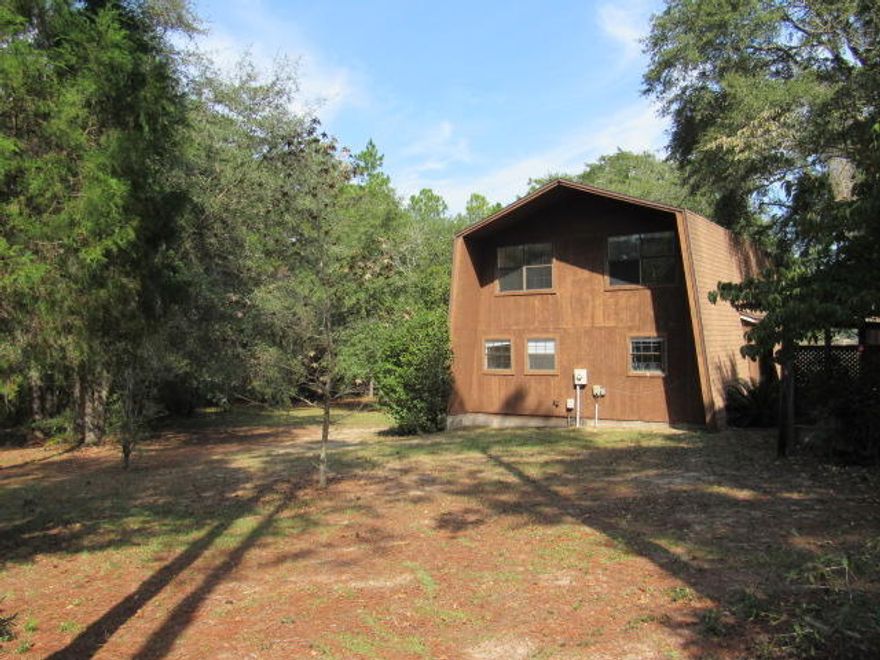 RECENTLY REDUCED!! Extra large lakefront lot on Juniper Lake, consisting of 3.25 acres. Dock in back yard just a few steps to fishing. Approximately 160 feet of lake frontage. Home is Mansard design with one bedroom and bath downstairs and two bedrooms and bath upstairs. LR overlooks the lake with large sliding glass doors. Spiral metal staircase to upstairs. Large screened back porch. There is a detached building with a half bath and large room that could be guest house. Two car carport. Home is outside city limits, yet close to town. Land is cleared around home and remainder is wooded.