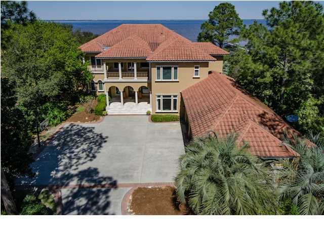 Awe-inspiring Bay-Front Estate with 132 linear feet of Prime Water Frontage in Kelly Plantation. Custom built by Frank Janssen, this thoughtfully designed home yields panoramic views of the Choctawhatchee Bay at every turn. Nestled among lush greenery, a two-story enclosed outdoor living area with gas grill, oversized pool and koi pond with tasteful stone work beckons calm Bay waters, offering exceptional privacy and serenity. A premium pier with docking facilities resting near a deep channel accommodates a 30 ft boat. Sweeping views of the Bay flow artfully throughout the home's wide expanse of windows, while the open floor plan mimics the breezy open-air feel of the surrounding landscape. This finely appointed showpiece includes raised and trayed ceilings, deep crown molding,
