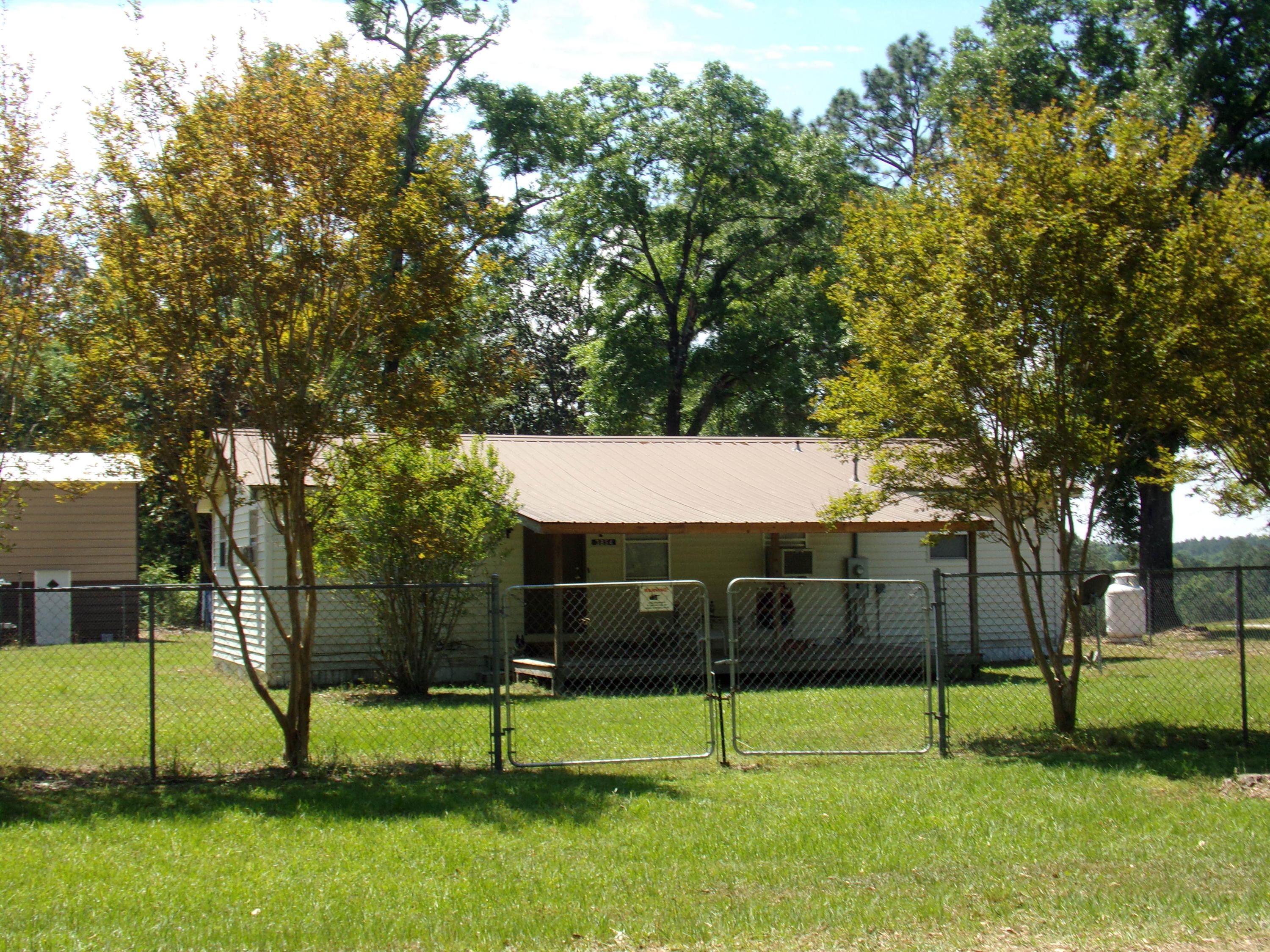 Country Cottage on large corner lot in the heart of Laurel Hill~ 2 bedroom 1 bath with updated country kitchen~ Large front porch and large screened in back porch to enjoy the peaceful country living~ Large 18' x 40' metal garage building with 14' tall x 12 wide roll up door~ Couple of outside workshops 12 x 12 & 10 x 10~ Water and power are out to the large metal building but not hooked up~ There is also water, power and septic hook up for travel trailer/motor home~ House/property being sold in current condition, AS IS~