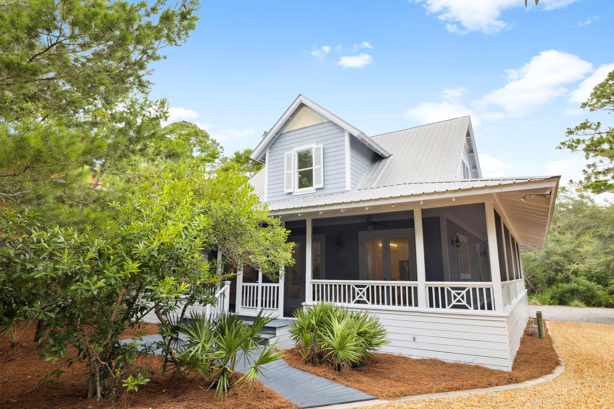 Stay tuned! Video with drone footage coming soon. Don't miss this opportunity at 385 Wilderness Way to embrace the 30A lifestyle among 20 lush acres! Live and play in the gated, tranquil neighborhood of Lake Place at Grayton Beach situated between 30A and Western Lake with private neighborhood dock and sparkling pool. Welcome to a beautiful bright and airy coastal retreat with carriage house. This charming Florida cottage at once welcomes you and embodies the laid-back vibe of Grayton Beach while sitting prominently on a large homesite with well-maintained indigenous landscape of magnolia, twisted oaks sculpted by southern breezes, tall pines, and bright green palmettos. Outdoor living abounds on the large, screened wrap around porch. This home offers a blend of privacy, modern amenities, and proximity to the natural beauty of acres of forest trails, bike path, state parks and Western Lake, a rare coastal dune lake. The main house features a spacious wrap-around screened porch, ideal for enjoying the serene surroundings, an eat-in kitchen with gracious countertop space and window over the sink, built-in bookcases, gas fireplace, and tall ceilings, plus an outdoor area ideal for grilling. It includes two bedrooms and a bathroom on the first level, with a full second level primary suite and loft for workspace. The Carriage House (built in 2019 according to public record) features private porch, living area with sleeping, full bath, kitchen plus washer and dryer making guest life easy. Enjoy convenient garage parking plus room for stowing away kayaks, standup paddle boards and bikes and grilling outdoors. The home is set back among native landscaping, offering privacy in a 20-acre, rental-restricted neighborhood with access to a community dock on Western Lake and a neighborhood pool. Just minutes from the Gulf of Mexico, residents can enjoy sunsets over the lake, kayaking, paddleboarding right off the community dock or relaxing by the sugar-white beaches of Grayton Beach State Park. Nature trails connect Lake Place to the forest for a walk with nature and state park passes are easily available for beach access or kayak or canoe to the beach. Visit Grayton Corners or Uptown Grayton both within walking distance and feature a myriad of shopping, eateries and more. We invite you to discover the gem of Lake Place at Grayton Beach, 385 Wilderness Way. It's all here waiting for you.