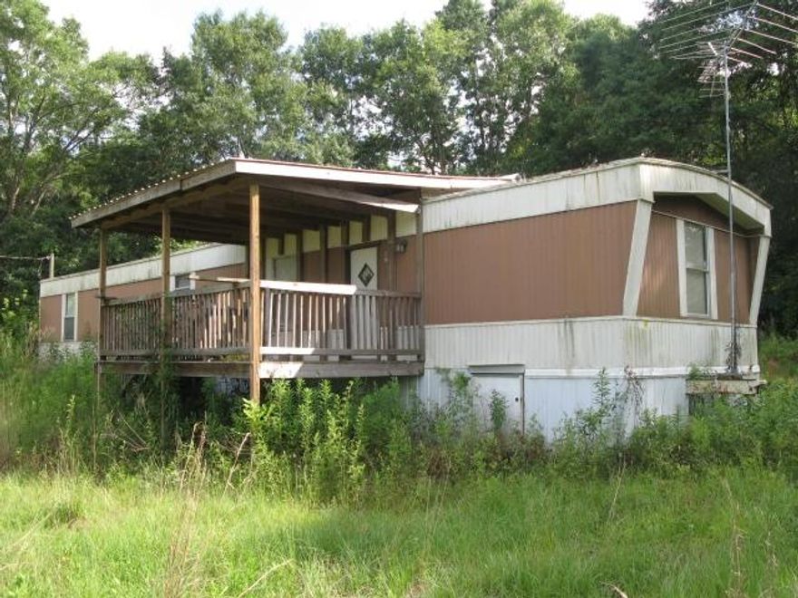 REDUCED. Just under 15 acres on paved road with 2 bedroom 2 restroom mobile home that needs a lot work, but could be fixed up. Mostly open farm land with small amount of wooded area. It looks like it has well, septic and electricity; buyer to verify. Selling in AS IS condition. Located in the country about 3 to 4 miles south of Alabama line.