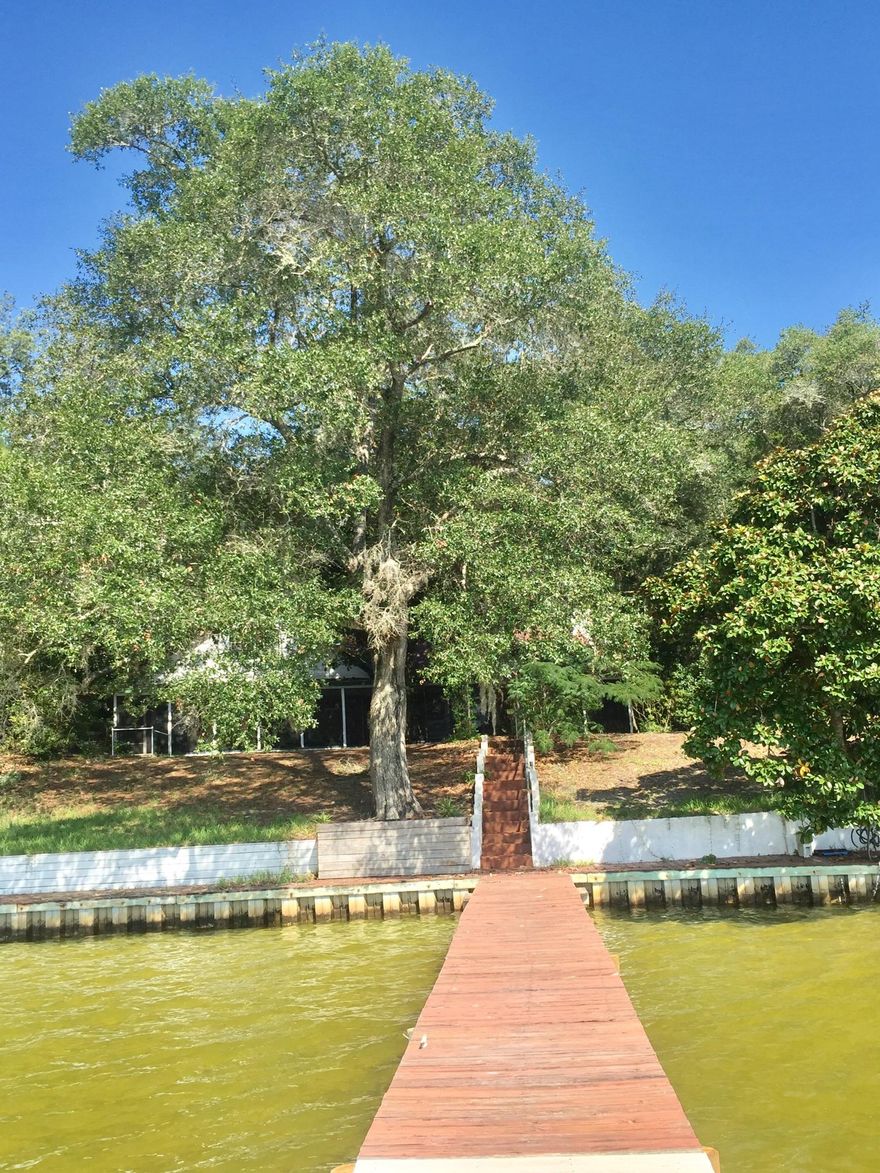 Beautiful, serene setting on Garnier Bayou in Shalimar allowing access to the Destin harbor and the Gulf of Mexico. Close to Eglin air Force Base, Niceville, Destin and Ft. Walton Beach. Deep water dock. Four bedroom, 3 bath home being offered As IS. One year old roof. Screened in porch spans the width of the house in the back. Gorgeous, mature magnolias and oaks providing good shade. Great opportunity to become a part of this quaint community.
