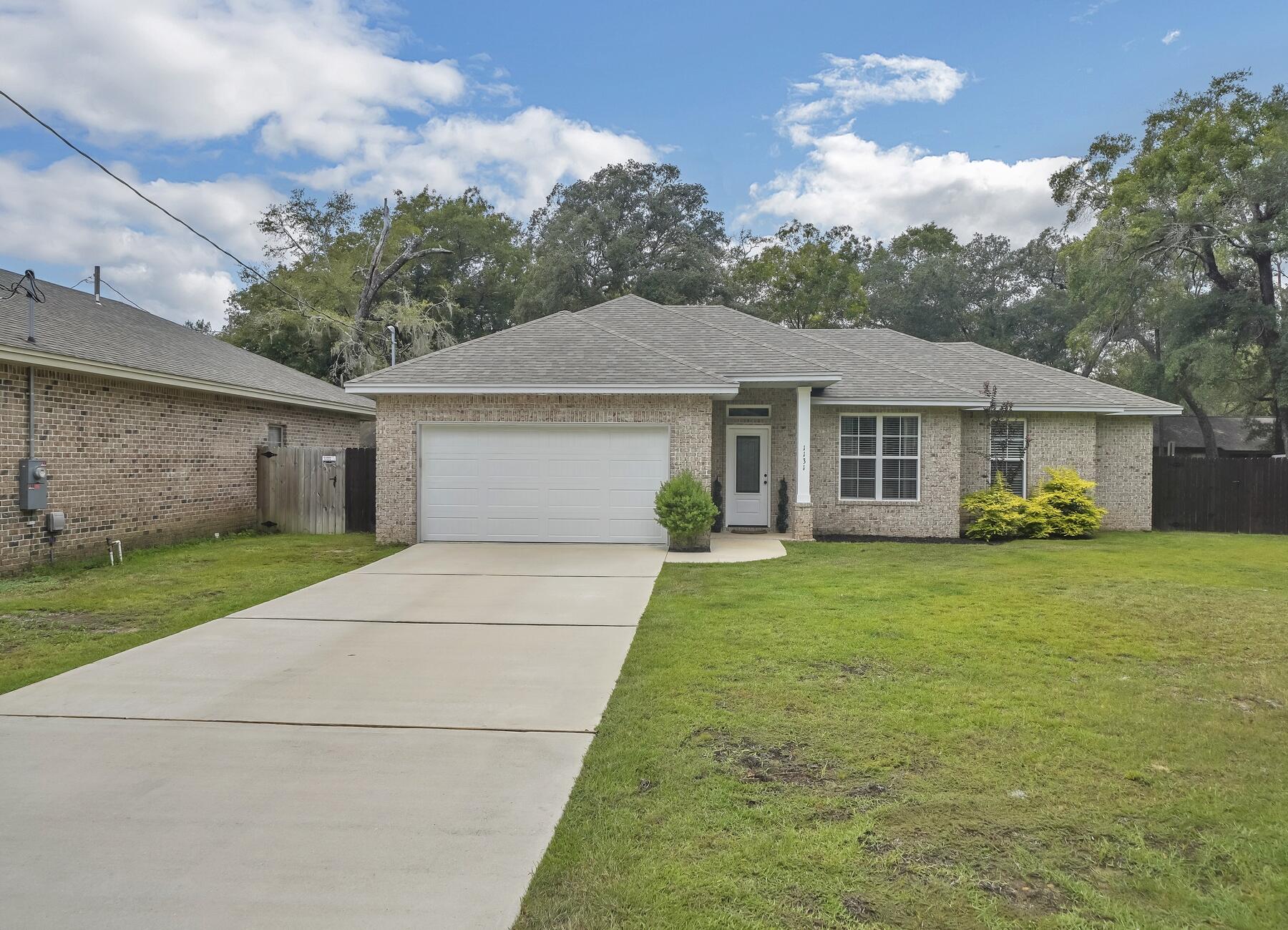 Beautiful better than new construction in the heart of Niceville. This home has been lovingly maintained and elevated by the current owners and is ready for a new family. Enter into an open floor-plan where everything feel bright and airy. The laminate wood flooring, crown moulding, and modern baseboards make for clean, welcoming atmosphere. The kitchen is complete with all stainless steel appliances, modern white cabinetry, and granite countertops. The split bedroom floor plan offers privacy for the primary bedroom. The primary suite is complete with a dual vanity, marble countertops, and a walk-in closet. Last but not least, the backyard has been finished with a new extended patio, rock for improved drainage quality, and lush grass.