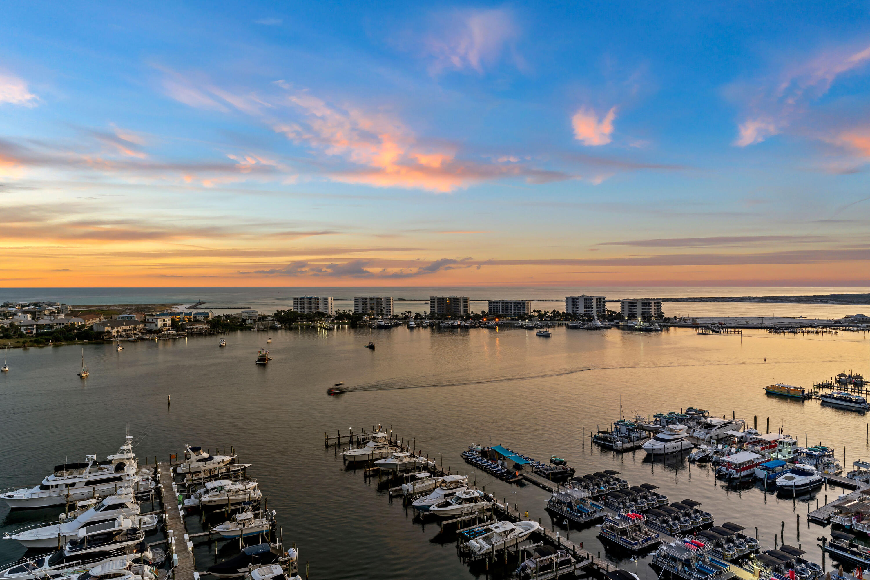 Welcome to Penthouse 1201 located in the iconic Destin Yacht Club, where sweeping views of the Destin Harbor to the Gulf create a stunning backdrop for refined coastal living. This rare corner residence features expansive windows and a spacious balcony that capture breathtaking views of the Destin Harbor and the Gulf of America. Perfect for the boating enthusiasts, this penthouse includes a deeded 55' deep-water boat slip. Destin Yacht Club is a private, secure gated community with world-class amenities, including a marina, resort-style pool, fitness center, and community room, ideally located in the heart of Destin. Your coded pedestrian gate gives you direct walking access to fine dining, shopping, and everything that Harborwalk Village and the Destin Harbor have to offer. Completely reimagined in 2023, the original multi-level floorplan was transformed into a seamless single-level design, offering both elegance and ease of living. Every detail was renewed to include electrical, plumbing, tankless water heaters, HVAC systems. With custom designer finishes the open-concept layout showcases soaring ceilings, a gourmet kitchen with premium appliances, and spacious living and dining areas ideal for entertaining. Sold fully furnished with sophisticated d??cor, it is truly lifestyle-ready and appointed for immediate enjoyment.
Complete building renovation including new windows & doors, exterior painting, new roof. Other enhancements include a complete lobby renovation and common area improvements. These areas offer a modern extension of the home offering multiple gathering and entertaining areas. The seamlessly fished indoor bar, common kitchen for all residents, outdoor bar, and fish cleaning station also enhance the coastal lifestyle and offer opportunities for social engagement.
Penthouse 1201 is a lifestyle-ready sanctuary where luxury, privacy, and waterfront living converge.