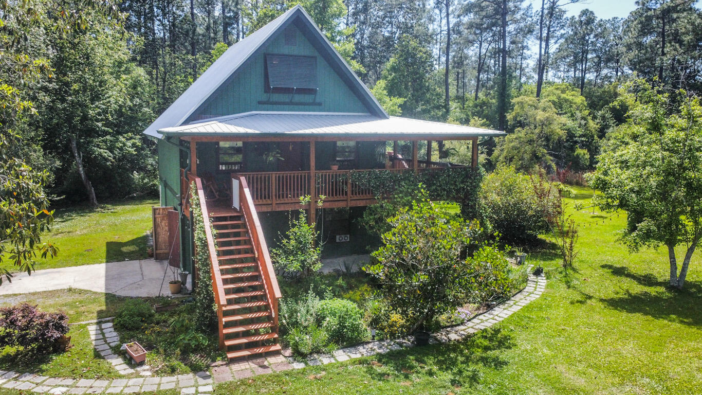 A quarter of a mile from Black Creek boat landing, and sitting on over 2.5 acres this property is perfect for anyone who loves the outdoors. A covered wooden deck wraps around the front and side of the home overlooking the beautiful grounds providing gorgeous views and privacy. Tons of potential for home additions can be found under the stilt home. The massive 2-story detached garage with loft provides great storage space, along with another separate storage shed at the back of the property.Additional parking located under the 2-vehicle carport! Rustic butchers block countertops with tile back-splash, and stainless steel finishes in the kitchen. The wood laminate flooring, and beautifully tiled bathrooms finish checking all the boxes off the list!