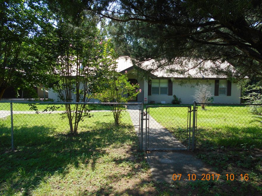 In the center of town on large fenced lot~ 3 Bedroom, 2 bath, formal living room, dining room and large great room with large Florida room, and office~ One car garage with 2 car carport~ Large back yard with Pecan & Fig Tree~ This has the country charm yet located in town~ With some updating this will make a wonderful home~