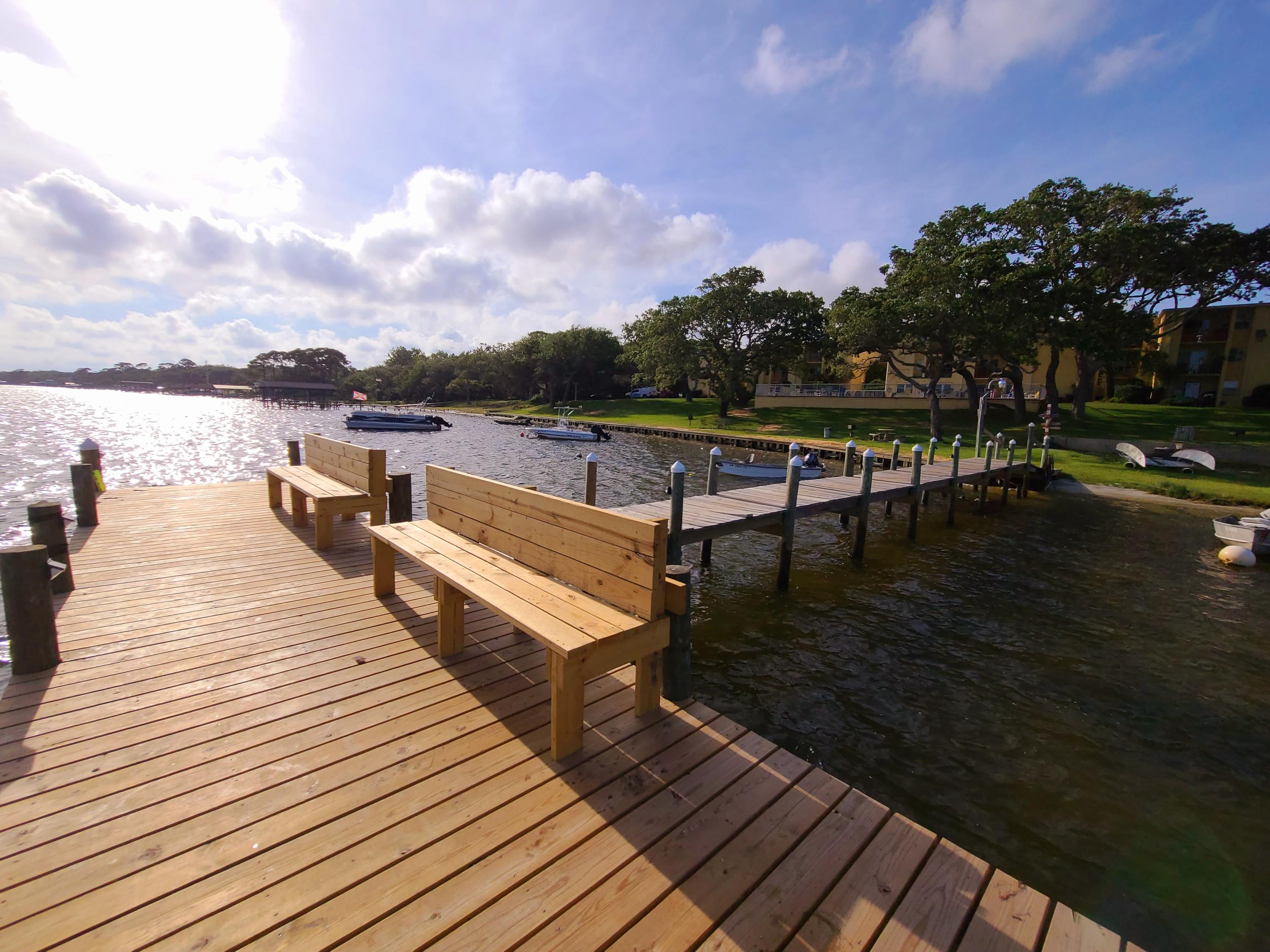 Grab your Paddleboard! It's feet to the water from your backdoor at this ground floor corner unit. One owner since it was built in 1974 and well-maintained since. Large living/dining area with lots of light with windows on the front and back and of course the GREAT VIEW! Large bedroom with separate entrance also has window with a view of the water. Tile flooring throughout is great to have living by the water.
Galley style kitchen has updated newer cabinets. Grounds are kept up by the HOA at one of the lowest HOA fees around. HOA pays water/sewer/trash/pest/grounds keeping/exterior maintenance (roof and siding, insurance). A small remodeling budget could easily take this condo to the next level. Sorry HOA Rules - No Short-Term Rentals and No Pets. ''AS IS'' Cash or Conventional.