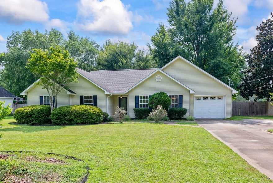 Classic country living at its best! This home is tucked away in a beautiful naturistic setting on a large lot where you'll find peace and ultimate privacy amid mature lush trees. You are welcomed to the home by lovely, manicured grounds and a sprawling green lawn that is flanked by an oversized driveway with plenty of space to park a boat or RV. As you approach the home, you'll be pleased by the appealing shrubberies, rose bushes, and mulch that perfectly accentuate the front of home complete with charming shutters and a one car garage. Entering, you are led into an adorable foyer where you will immediately notice the wonderful use of square footage and attractive laminate flooring running through main living area.  As you step into the quaint living room you are delighted by