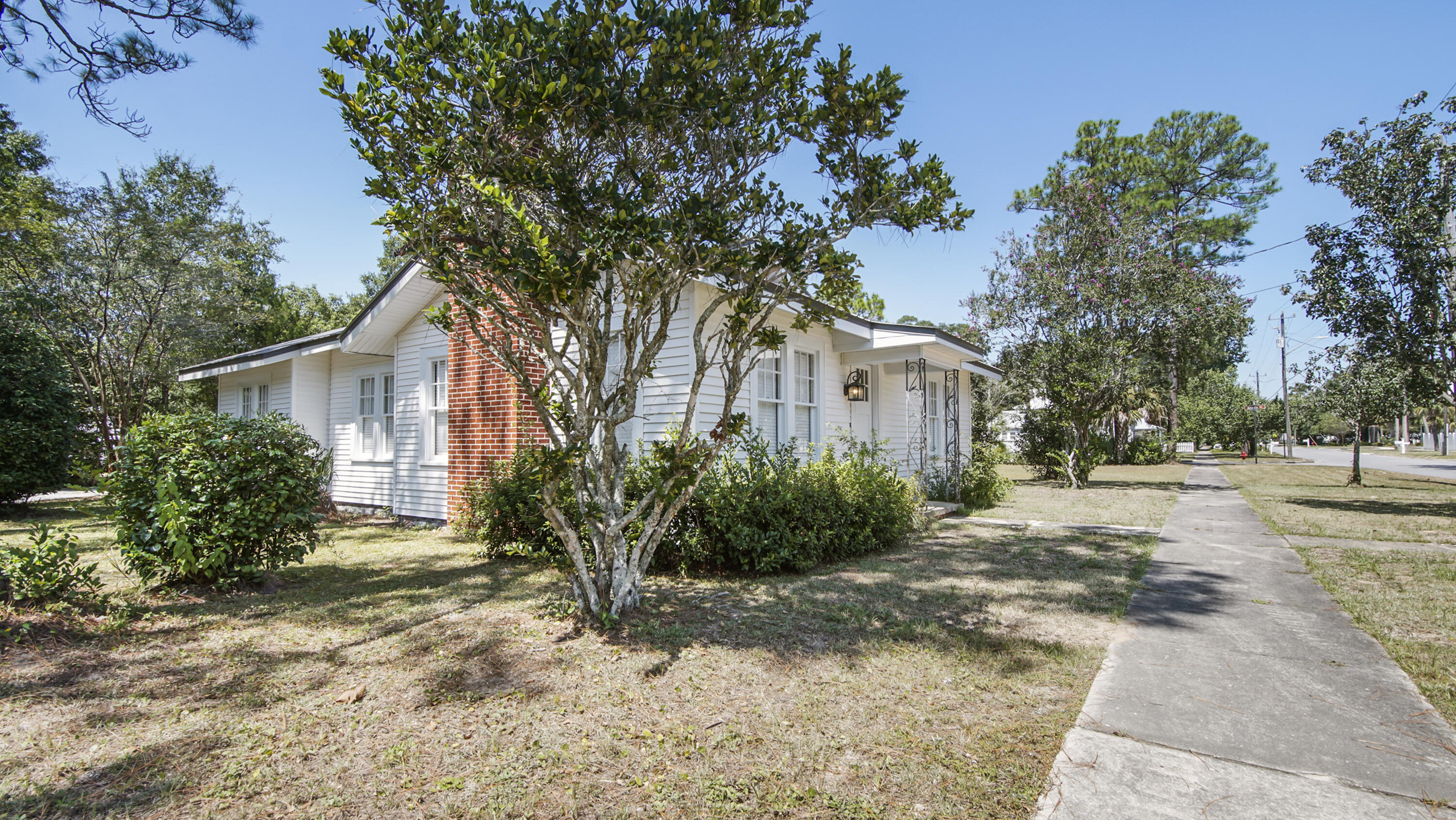 Move-in ready, in historic downtown DeFuniak Springs, blocks from Lake DeFuniak and across the street from Florence Park. The large, sunny rooms and hardwood floors welcome you into this inviting, renovated home with metal roof and new HVAC. The adjoining lot next door is available for purchase for an additional $50,000 (only available to buy as home/lot package - water and sewer tap paid - a $10k+ value). New paint, new appliances, updated kitchen and baths with newer windows - yet the charm remains with the original doors and hardware, real wood floors. The spacious dining room could be a 4th bed or flex space too. The screened porch/breezeway doubles as a comfy and cozy hangout space. Qualifying for all financing, don't miss your opportunity to own a downtown DeFuniak Springs cottage!