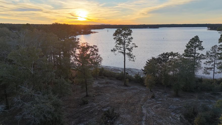 Over 31 acres with approximately 350 feet of frontage on Juniper Lake, offering a rare opportunity for expansive waterfront living in DeFuniak Springs. The property features lake frontage along Hwy 83 North and is located just 35 miles from the white-sand beaches and emerald waters of the Gulf.Situated approximately 250 feet above sea level, this property is not in a flood zone and is positioned inland from the hurricane-prone coastline. A palm-lined entrance leads to a mature oak hammock and opens to elevated, panoramic lake views with stunning sunset vistas.Ideal for fishing, building a private estate, or keeping for a long-term investment. A 40' x 60' newer pole barn adds immediate utility. A rare combination of lakefront acreage, elevation, and proximity to the beach!