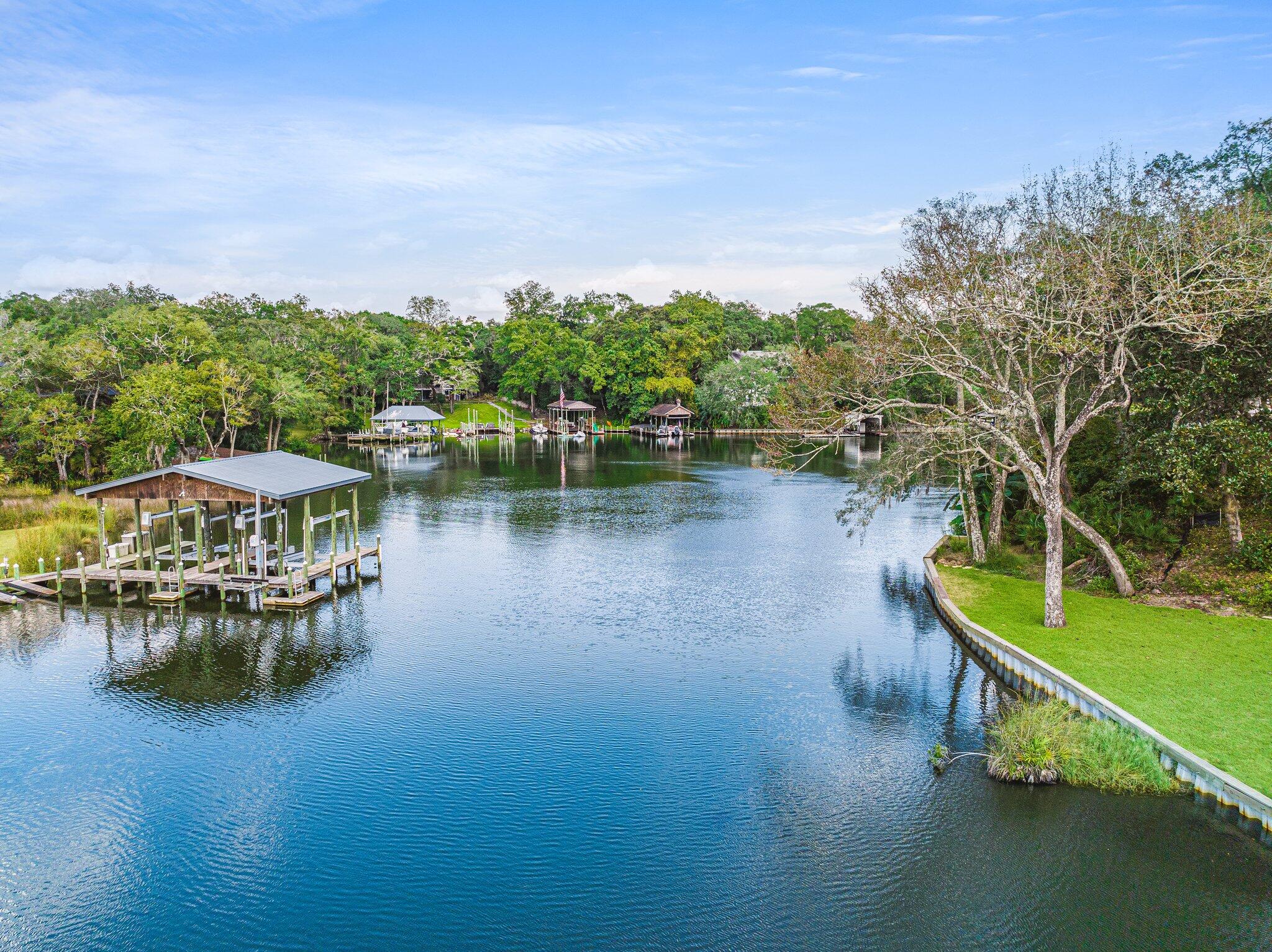 Custom Craftsman style waterfront home on a private road with 213' of protected waterfront. This exquisite 4 bedroom 4.5 bath all brick home has so many unique features that make it a one of kind home. Located within walking distance to a playground, pickle ball courts & city golf course. The moment you enter the home the special details are hard to miss, from the over-sized island in the kitchen, a gas fireplace with a custom 14' Sycamore tree mantle, views of the bayou, & over 900 sqft of decking for entertaining friends & family. The home features 2 primary suites both with French doors leading to outdoor decks. The lower level features a massive media room & pool table area, a brick wet bar with a custom top hand-cut from a Laurel Oak tree, & a 72' heated & cooled safe room.