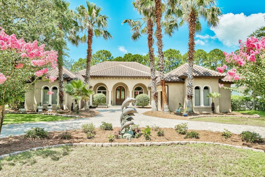 Looking for a bit of elegance in a sea of coastal casual? This home checks every box. Stunning views of Regatta Bay's two tee box and fairway. Private corner lot backing up to a woodland nature preserve. Heated saltwater pool with waterfall. 100 bottle custom wine room. It is a piece of Italy nestled in the much-desired area of Regatta Bay's Captains Circle.The exterior evokes a fashionable villa straight out of Tuscany with smooth hand-stained stucco and distressed concrete stone pillars and window trim. Your visit begins with entry through custom 11-foot cedar double front doors finished with beveled glass. A jaw dropping 35-foot barreled ceiling colonnade supported by distressed concrete pillars runs the length of the living/dining/music rooms while Venetian plaster lines the walls