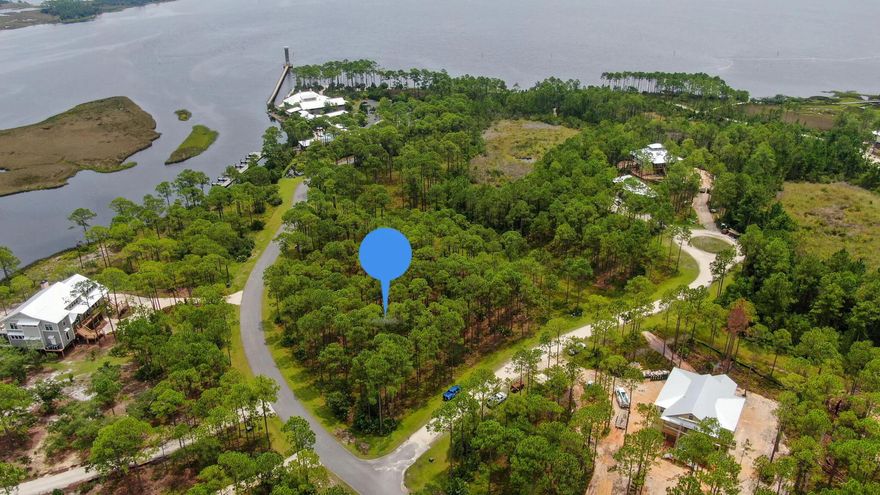 Situated in a serene natural setting with its prime location VERY close to the Pool AND the BAY, this 1.26 acre lot offers a flexible buildable footprint and a rare opportunity to enjoy natural beauty with stunning water views. This lot's location affords you the flexibility to design a home that matches your lifestyle and aesthetic tastes. Rivercamps is a vibrant, growing community along the natural beauty of the bay in Panama City Beach. It offers serene, waterfront living, creating a perfect balance between nature and convenience. The community is designed with outdoor enthusiasts in mind - Amenities include access to West Bay and Crooked Creek; a boat ramp; future pool and cabana; seven miles of trails and boardwalks; and even a waterside campsite