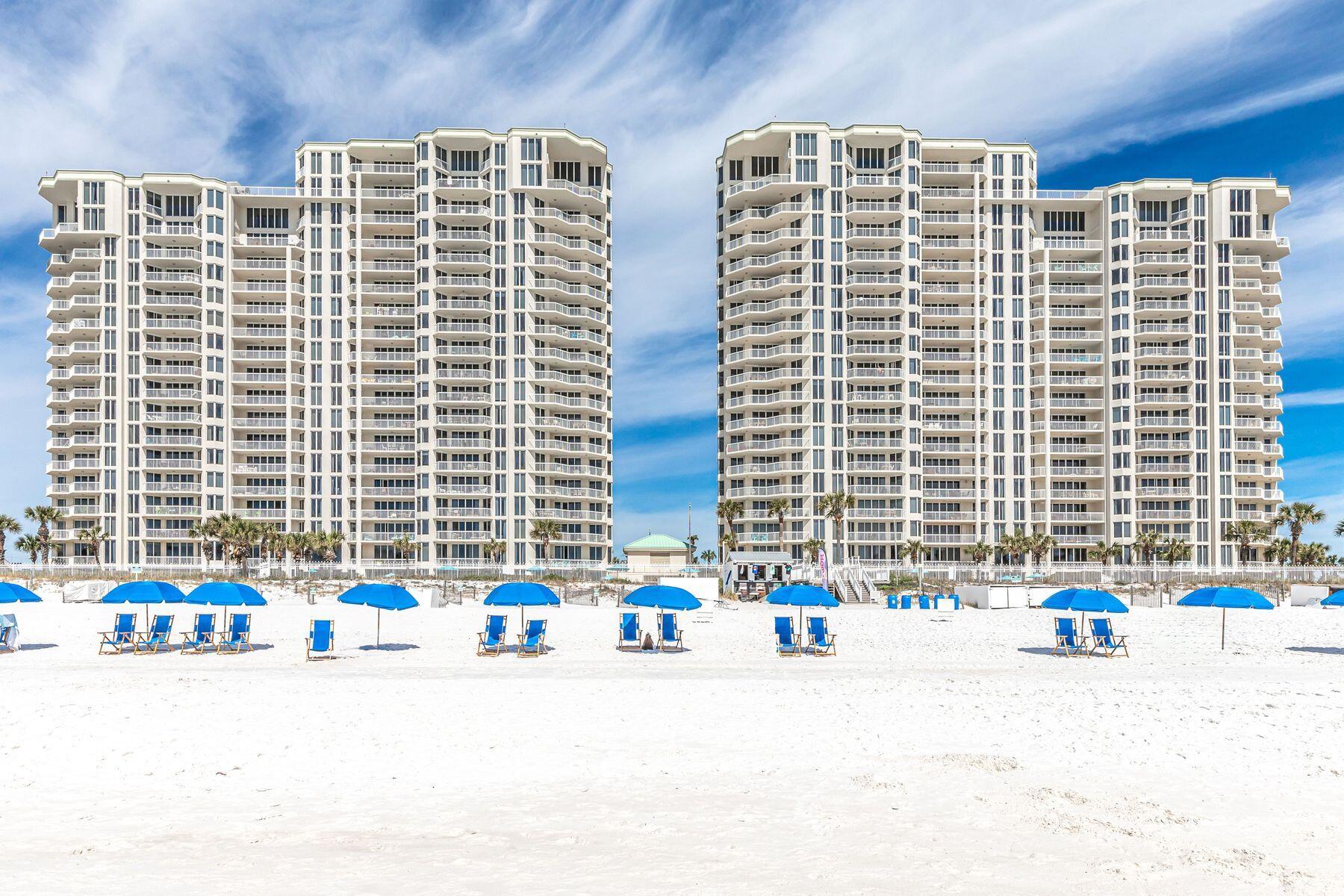 Seller offering to pay for two years of HOA dues to any buyer that closes before June 30th, 2025. Beachside food and beverage service coming in 2025 to Silver Beach Towers! Who wouldn't want yummy food and tasty frozen drinks delivered right to their beach chair? Offering panoramic views, this completely remodeled gulf-front condo has a popular split floor plan. It is beautifully presented with all-new lighting, custom window treatments and graceful furniture included in the sale. New engineered wood flooring flows throughout the unit, giving way to new tile floors in all three bathrooms. The entrance hall welcomes with tasteful board and batten walls. It leads to two large guest bedrooms, both with generous private bathrooms and access to a private balcony. The hub of the home is the bright open living room, featuring plentiful windows and sliding doors onto the main balcony. Serve drinks from the beverage refrigerator at the custom bar before putting your feet up in this comfortable living space