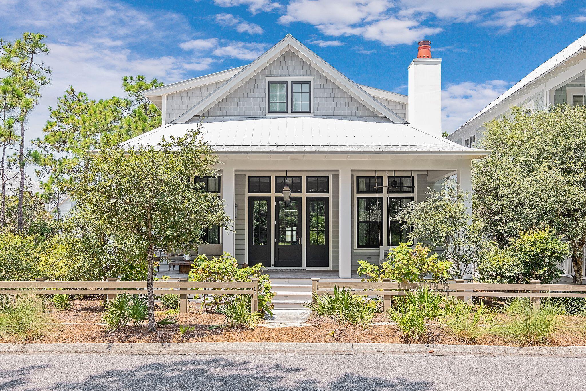 This phase 3 Watercolor beach house, designed by Dawn Thurber, built by Romair homes and beautifully decorated by Kirstie Carollo of Bella Beach offers 5 bedrooms, 5 1/2 baths and is 3,224 square feet and radiates southern beach charm!  Upon arrival of the home you will take note of  the sizeable front porch finished with Satina Brazilian hardwood decking and an inviting swing bed that overlooks one of the many green spaces that Watercolor has to offer. As you enter the home you will immediately be welcomed by the soaring 12 foot raised ceiling with gorgeous white architectural beams, walls adorned with floor to ceiling white shiplap and an open floor plan that is light and bright and perfect for entertaining guests and enjoying family time! The living area is large yet cozy with a 48