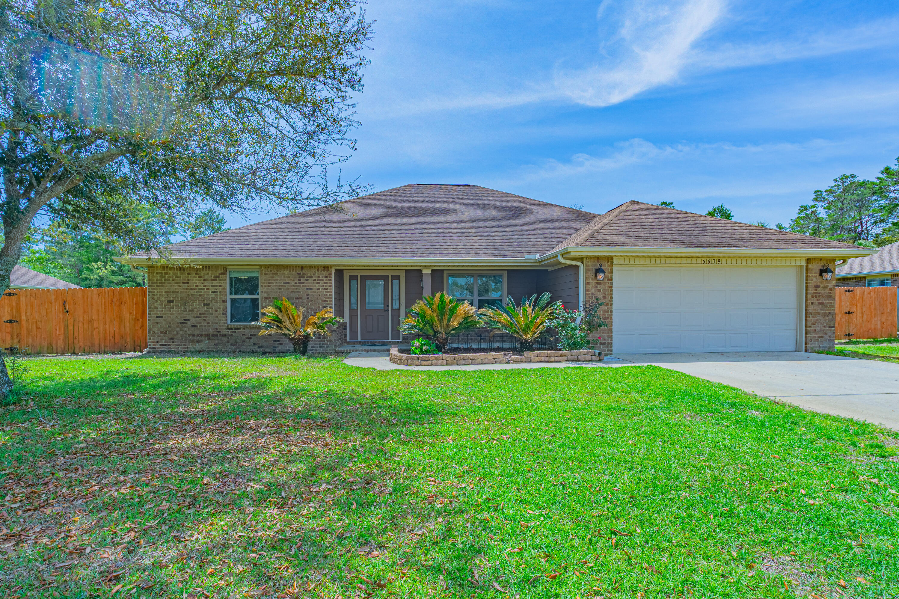 VA Assumable with a interest rate of 2.35%. Need room? Look not further, beautiful and spacious home located in Holley by the Sea. This home offers a split floor plan with four bedrooms, three full bathrooms, a formal dining area, breakfast nook, and an enclosed Florida room with heating and air.  If that's not enough there's a 15 x 20 out building with it's own heating/air and windows for natural light, use as a office, art studio etc.  The home layout includes two guest bedrooms at the front of the home that share a bathroom, and a third guest bedroom with a private bath--ideal for guests, in-laws, or teens. The large primary suite is located on the opposite side of the home  for added privacy and includes a tray ceiling, ceiling fan, and a door to Florida room, (see more) Primary bath has a walk-in closet, double vanity, garden tub, and separate shower. The kitchen features granite countertops, a breakfast bar, tile back splash, under cabinet lighting, walk-in pantry, and stainless steel appliances. Spacious inside laundry room offers plenty of storage. Recent updates includes luxury vinyl plank flooring throughout most of the home, with carpet remaining in the primary bedroom. Oversized garage and long driveway for plenty of parking. Situated on nearly half an acre, this home also includes access to Holley by the Sea's community amenities which is located on 45 acres on Santa Rosa Sound. Amenities include two swimming pools, baby pool, state of the art workout center, sauna, steam room, tennis courts, playground, camping, dock, deed access to the sound, a rental building for private parties, boat lauch to East Bay.