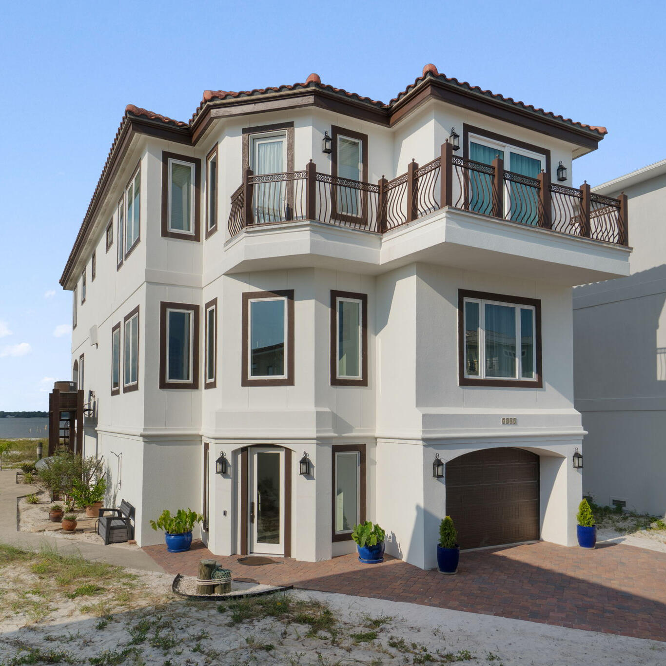 Exquisite Waterfront Residence in Sailmaker Cove. Step into a world of luxury and tranquility with this stunning waterfront home, nestled within the prestigious, gated community of Sailmaker Cove. This custom-built residence seamlessly blends timeless coastal design with elevated Mediterranean elegance, surrounded by the serene landscape of Gulf Islands National Seashore.Upon arrival, the property makes an immediate impression with its elegant white stucco exterior and Spanish cement tile roof, complemented by a beautifully designed wrought iron balcony offering captivating views of the Gulf and it's pristine sugary beaches. Spanning over 3,794 square feet, this meticulously curated 4-bedroom, 5-bathroom home is designed to elevate your lifestyle and spirit. The first floor features an open-concept layout, perfect for gatherings, that effortlessly integrates into a chef's dream kitchen, adorned with high-end, custom solid wood cabinetry and stone countertops. Imagine dining while savoring breathtaking sunsets from the comfort of your home.
Additional highlights of the first floor include a spacious bedroom suite with a luxurious bath. Tiles and hard wood flooring and a host of subtle custom finishes thoughtfully designed throughout the home such as imported sinks, a stunning cement wall for showcasing your favorite wines, and exquisite 19th-century European stained glass above bedroom doors and throughout selected walls really showcase this spectacular home. The spacious primary suite on the second floor serves as a true retreat, boasting a cozy sitting area, custom built-ins, and a private balcony with breathtaking views of the Gulf. Two additional guest bedrooms, each with en-suite baths and picturesque views of the sound and national park, provide ample space for family or guests.The garage is equally impressive, with high ceilings and generous storage space, including an area designed for a golf cart.
The rear exterior of the home is perhaps its most enchanting feature, inviting you to relax or entertain at any time of day while being embraced by nature. Whether you prefer watching dolphins swim or enjoying a peaceful read, this unique setting promises to be a spectacular experience.Conveniently located just across from a tranquil, less-crowded beach. Take a short, scenic ride through the park to the vibrant Pensacola Beach for an array of dining and entertainment options. Sailmaker Cove provides a serene gated community experience, bordered by natural beauty, including the stunning Santa Rosa Sound.
Residents also have access to the refreshing community pool, making this property an ideal choice for a primary residence, vacation home, or a lucrative short-term rental opportunity. This home is truly a rare gem that will not disappoint!