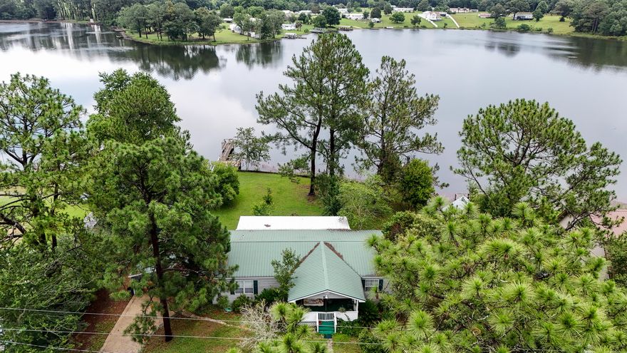 PARADISE ISLAND SAYS IT ALL! Come and make this your address. This well-maintained home offers the perfect location for those looking to enjoy lake life. Watch the sun come up on the porch with a cup of coffee and watch it set with a glass of wine without ever leaving your home. Fish from your own 32 ft. pier or launch your boat from your own covered boat shed. Bass, bream and other freshwater fish are plentiful and waiting for you! More than 130 feet on Kings Lake with bulkhead in place. New storm windows installed throughout and hurricane shutters there when needed. A large sunroom and enclosed Florida room across the back of home add more living area for entertaining. Owner has an Elevation Certificate, no flood insurance is required. Lot is level and a great place to enjoy outdoors.