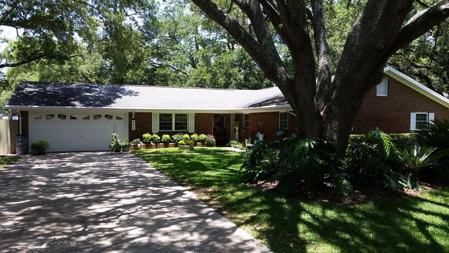This wonderful home shows pride of ownership from the street and throughout. Sitting on a corner lot, the mature trees offer shade while still allowing enough light for the lush gardens. The owners are very busy so they wanted the landscape to be maintainable but still have character. The side garden has peaceful areas including a custom, raised fish pond. The backyard is spacious with different areas designated for multiple activities. The custom deck offers an outdoor kitchen with sink and plenty of counter space. A portion has a custom vaulted ceiling covered seating area. One corner of the backyard has a tranquil sitting area around a firepit. New Zoysia grass and a storage building round out the back. The interior offers four bedrooms (one currently used as a den with a home office.