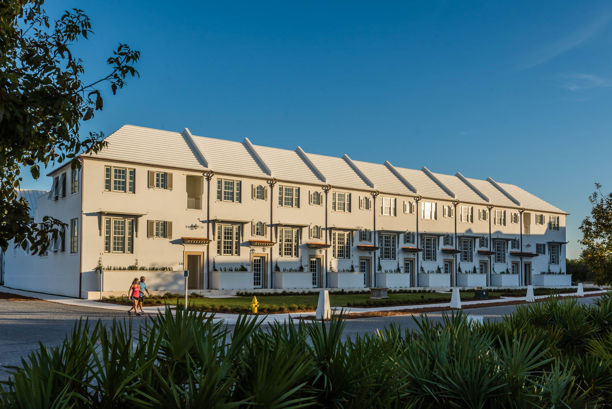 The newest completed homes in Alys Beach, Caliza Courts form a welcoming addition to the breathtaking Caliza Pool location. Designed by Khoury Vogt Architecture, the rowhomes are graced by an attached park along Somerset Street, with raised stoop entries bordered by landscaped planters. Brilliant details in design have been woven into these centrally located rowhomes.Finished in the artisan applied Venetian Plaster, the entry and stair hall ushers one in the main living area, elevated half a floor above grade. Spanning the width of the homesite, the light filled great room has a 16-foot ceiling and 12-foot tall French doors and windows that open to a private courtyard and guest suite beyond. The great room also features the reflective Venetian plaster finish on walls and ceiling.