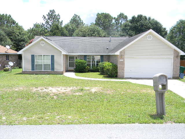 SOUTH OF I-10, CLOSE TO I-10, ALL MILITARY FACILITIES, SHOPPING & BEACHES!!! This 4/2/2, 1969 sf home built in 2001 is waiting for you!! Great neighborhood, large lot & very functional home. Large family room with formal dining located to the right of entry. Kitchen equipped with breakfast bar, breakfast nook overlooking the back yard, pantry, plenty of cabinets & counter space, stove, dishwasher, microhood, refrigerator(as-is/not warranted.) Laundry room w/cabinets also. Popular split B/R plan features beautiful tiled floors throughout the family, dining, kitchen, laundry, hallways, baths & 1 B/R. Other three have carpet. Master Bath has new tile, double vanity, 2 walk-in closets, garden tub, separate shower. Double French doors lead