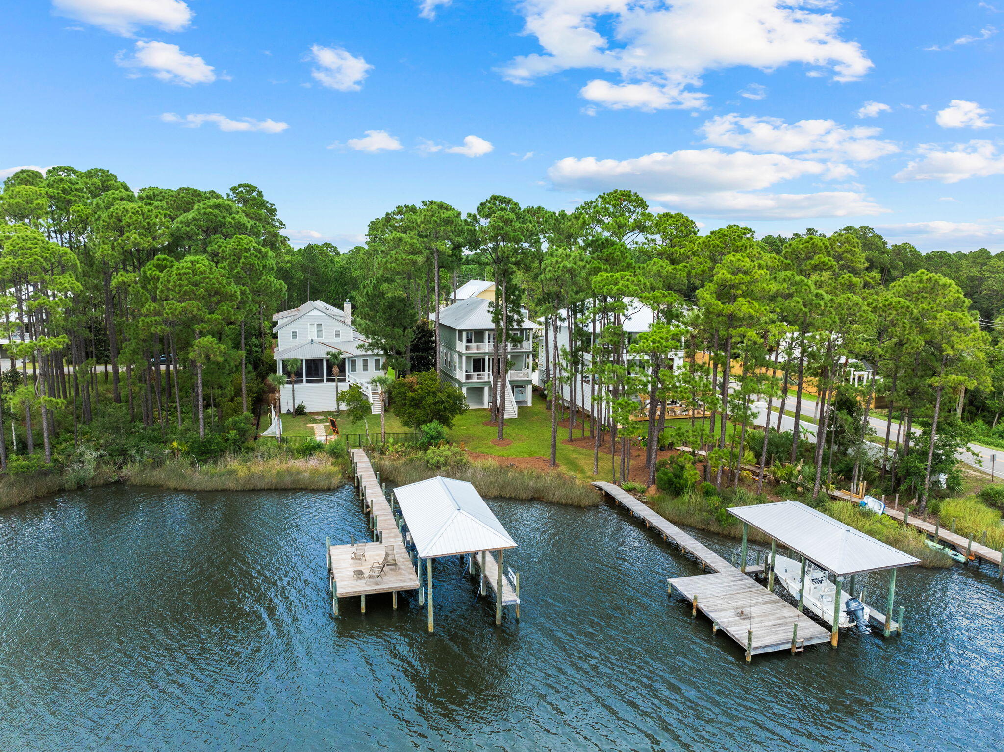 Bayfront living meets coastal charm in this picturesque residence, situated in the private, gated community of Cessna Landing. Ideally located just 3 miles from Gulf Place and 30A's beaches and positioned on the Choctawhatchee Bay, this home offers a serene setting where coastal nature abounds.The home features full-width porches on each level, including a newly screened-in porch on the main floor, providing versatile outdoor living and entertaining space. The expansive backyard banks to your private dock with Hi Tide boat lift, perfect for boating, sunsets, and quiet mornings overlooking Hogtown Bayou. The first-level garage spans the length of the home, with parking for up to three vehicles and ample storage--ideal for water toys, equipment, or a home gym. Adding to the outdoor experience is a classic barrel sauna for unwinding after a day on the water or a workout in your at-home workout. Inside, the home is designed to take full advantage of bay views with a generous open floor plan and 18-foot sliding doors that bring light and warmth into the main living area. The primary suite offers water views and its own porch access, while three additional bedrooms invite plenty of space for family or guests. A wood-burning fireplace, charming cottage trim, and wired sound system throughout complete this one-of-a-kind waterfront residence.
The Cessna Landing neighborhood features a gated entrance, well-lit streets, a community pool, and a private dock, offering everything you need and more for the ultimate waterfront living experience.