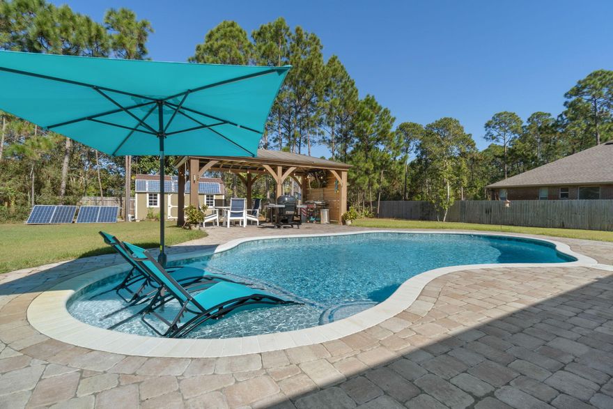 WELCOME HOME to Florida living at its best. This gorgeous custom built 4 bed 3 bath POOL home is exquisite inside and out.  Conveniently nestled in Hidden Creek enjoying all the amenities including :Pools,Fully Equipped Gym,Tennis Courts,Waterfront Park & Deeded Access to Santa Rosa Sound .Just a short drive to the local stores and the breathtaking white sandy beaches of the Gulf of Mexico.Your 2826 sq ft. home is only 3 years young with all those wish list extras already taken care of for you.Your back yard Oasis offers a Gunite pool with sun shelf~wrap around paver pool deck & undercover porch. Gazebo to cook out and enjoy those wonderful Florida evenings & the outbuilding is fully finished space with power and an AC mini split running from your own little solar farm ~all enhancing your little piece of paradise.
This custom-built home greets you with pleasing curb appeal,3 car garage and additional side parking for your RV or boat. Sweeping front porch opens to the foyer~home to your large office and formal dining room flowing through to the family room with high waffle ceiling and patio doors that lead out to the covered porch. This open floor plan boasts gorgeous wood plank tile that runs throughout the home. ~ high ceilings, decorative trays and the coastal color palette radiates a light and bright feeling throughout. Gourmet kitchen with staggered shaker cabinets, granite & quartz countertops, backsplash, walk in corner pantry, farmhouse sink and S/S appliances. The large sleek top island overlooks the breakfast nook offering lots of seating options for entertaining. Master bed has views of the pool while the luxurious master bath offers a his and her vanity area, deep soaking tub, separate corner tiled walk-in shower with dual shower heads and access to the oversized walk-in closet. This split floor plan home offers a hallway to two of the additional bedrooms with ceiling fans and a Jack & Jill bathroom ~ step in tub/shower & WC with separate closet /vanity areas. Third additional bedroom is separate from the other rooms and would make a perfect guest/teen suite with its own bathroom and access out to the covered porch. Large walk-through laundry room has additional cabinet space with granite countertop and under-mount sink and still has room for a bench and hanging space. The 3-car garage is ideal for the larger trucks and still plenty of room for all the outdoor toys. Home is situated on a large lot with grassed yard ~sprinkler system~ lawn pump and well with digital programmable timer for easy care. TAEXX in wall pest control system~ Fabric Shield Hurricane protection and dimensional shingle roof for lower insurance premium. Upgrades include crown molding, recessed lighting, framed mirrors, deluxe lighting package,50 Gallon water heater, upgraded Bosch High efficiency AC Unit, Gas Hot water circulating system, garage door remotes, attic drop down stairs~ to name a few.... ... Relocating to Hurlburt Field ...no problem you are within a 30 minutes' drive from the front gates and still conveniently nestled between Pensacola and Destin with easy access to both local airports and a straight drive North on Hwy 87 to the I-10. Call today to schedule your private showing.