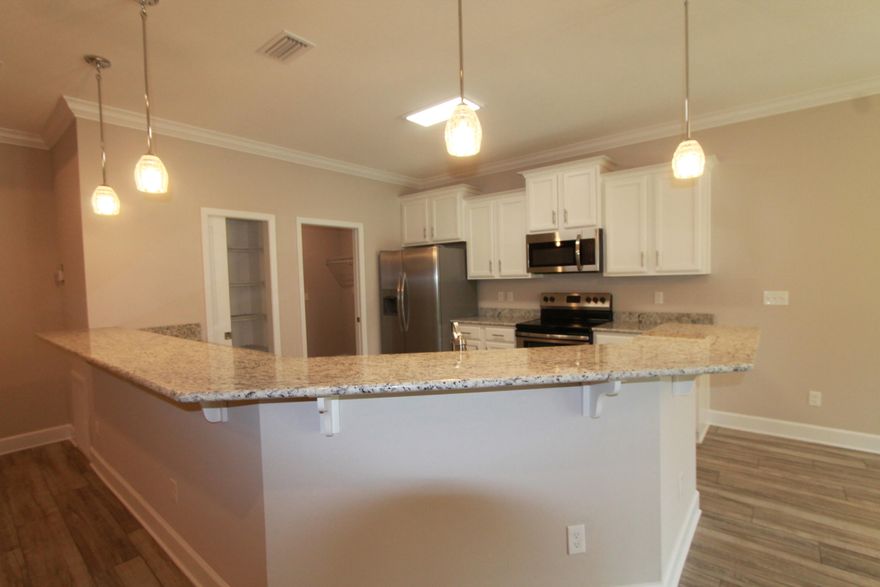 Back on the market, loan fell through at the LAST minute. This custom 3/2 floor plan has super curb appeal!! Great location!!! Tom Street is on the North side of Hwy 98, just 1 minute past the Santa Rosa County line. 9 Ft. ceilings are throughout main living areas. Ceramic wood look tile flooring is throughout the entire home . Kitchen opens to the dining area and has custom cabinetry, a breakfast bar, granite countertops, and stainless appliances, including a refrigerator/ freezer. Living room is located at the front of the kitchen, is oversized, and boasts a trayed ceiling. There is an upgraded lighting package. Master suite has a trayed ceiling,