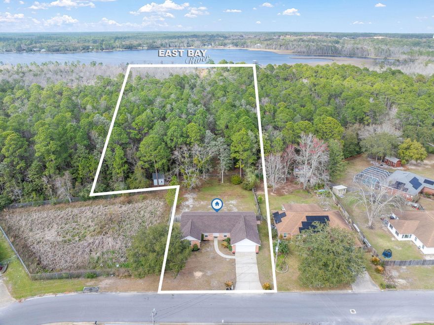 ALMOST 5 ACRES OF PREMIUM WATERFRONT PROPERTY ON EAST BAY!  Ready to go boating, swimming, fishing or kayaking?  Come see this 4 bedroom, 2 bathroom home with large fenced in backyard with a path to the water on East Bay.  Inside you will find a large eat in kitchen with loads of white cabinetry and a pantry.  Attached is added entertaining space in the formal dining room.  There is a large living room with vaulted ceilings PLUS a bonus office space or home-schooling room.  Spacious master bedroom with an attached 5-piece bathroom, that has his and hers closets, garden bathtub and dual sinks. This home has a split bedroom floor plan with three additional bedrooms and full bathroom. Did I mention it is in a Flood Zone X, wherein flood insurance is not required.  Roof is new in 2025. Windows and sliding glass door were new in 2009 and come with a lifetime transferrable warranty.  The large fenced-in yard has room for a swimming pool and the lawn has a sprinkler system with new lawn pump.  The home comes with a transferable termite bond.  The property is deeded all the way to East Bay with a Wetlands Jurisdiction area beyond the back yard. There is plenty of room to put in a boat dock/boat slip and have immediate access to Pensacola Bay.  Don't miss this fantastic opportunity to have an almost 5-acre waterfront home!