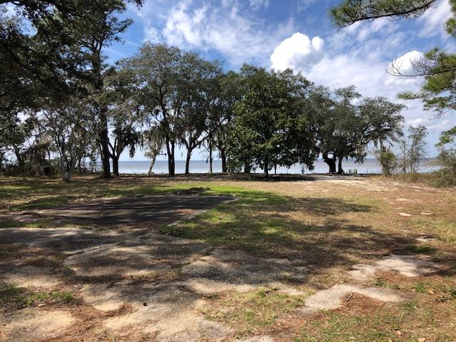 Enjoy the azalea lined driveway onto the most beautiful lot on East Bay where you'll experience sunsets like no other setting. Beautiful oak and magnolia trees cover this lot and surround your private pond. Fish for bass or bream in the pond or Reds and speckled trout in the bay. This 1.42 acreage is two lots that have 200ft. of waterfront with a boat ramp! It has a seawall with riprap protection and remnants of a pier means no permitting issues for rebuilding. Property has water lines. Conveniently located in Gulf Breeze only a short distance to restaurants, shopping, schools and beaches.