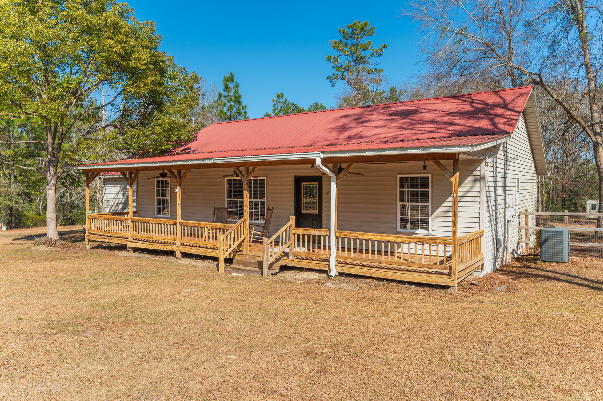 Charming 1,625 sq ft ranch-style home on 3.85 acres in DeFuniak Springs, just south of I-10! This 3-bed, 2-bath home features rustic upgrades, new ceilings, and beautiful raw wood flooring. The kitchen boasts granite countertops, a farmhouse sink, and ample cabinet space. One guest room includes a unique built-in loft bed, perfect for maximizing space. The garage has been partially enclosed to expand the laundry room and en suite, now featuring a walk-in shower, double vanity, and a spacious walk-in closet. Plus, built-in dog kennels in the garage provide a space for your fur babies. The roof, HVAC, and water heater were installed in 2017-2018. Country living on a county-maintained road, this property offers space, privacy, and modern comfort in a serene setting.