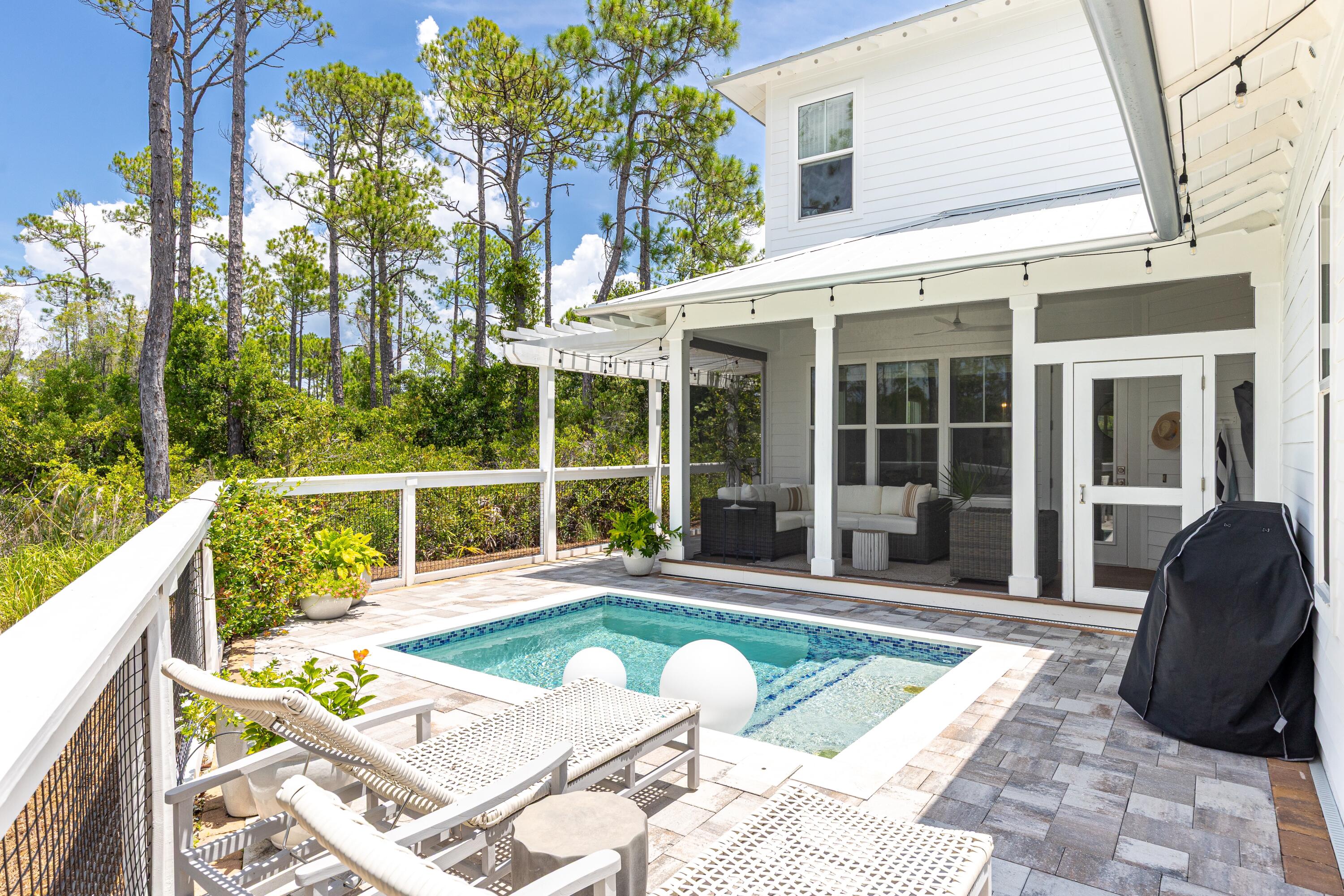 Beautifully situated on one of the premier lots in NatureWalk at Seagrove's final phase, 235 Prairie Pass offers the perfect blend of luxury, privacy, and outdoor living. Backing to a serene wooded preserve and overlooking a tranquil pond, this 5-bedroom, 4.5-bath Seagrove plan showcases thoughtful design and high-end features throughout--including a resort-style saltwater pool, outdoor firepit, and lush backyard retreat perfect for entertaining.The home's layout is both functional and elegant, with a first-floor primary suite, dedicated study (currently used as a music room), spacious upstairs loft/flex space, and 2-car garage. Soaring ceilings and large windows fill the two-story living room with natural light, enhanced by stained wood beams and V-groove paneling above the fireplace.
At the heart of the home, the chef's kitchen impresses with white shaker cabinetry (glass uppers with LED lighting), quartz countertops, subway tile backsplash, and GE Monogram appliances including a 48" refrigerator, gas cooktop, range hood, built-in oven, microwave, and dishwasher. The oversized kitchen and dining area provide ample space for gathering and entertaining.
The primary suite on the main level features a spacious bedroom, large walk-in closet, and a luxurious master bath with dual vanities, shaker cabinetry, and white quartz countertops. Upstairs, four additional bedrooms and a loft/flex space offer versatility for guests, work, or play.
Step into the backyard and enjoy a resort-inspired escape with a glistening saltwater pool, firepit, and pond views, all designed for effortless indoor-outdoor living. The home also includes several smart and energy-efficient upgrades, such as a fully automated pool system, automatic patio lighting, dedicated outdoor LSV outlet, and a 50-amp EV charging circuit in the garage.
Residents of NatureWalk enjoy access to The Gathering Place, an amenity-rich community hub featuring a heated lap pool, zero-entry pool, hot tub, fire pit, grilling stations, pickleball, multi-purpose courts, fitness trails, and abundant green space. A scenic nature trail through the forest offers direct access to the beach, placing you just minutes from the best of 30A.