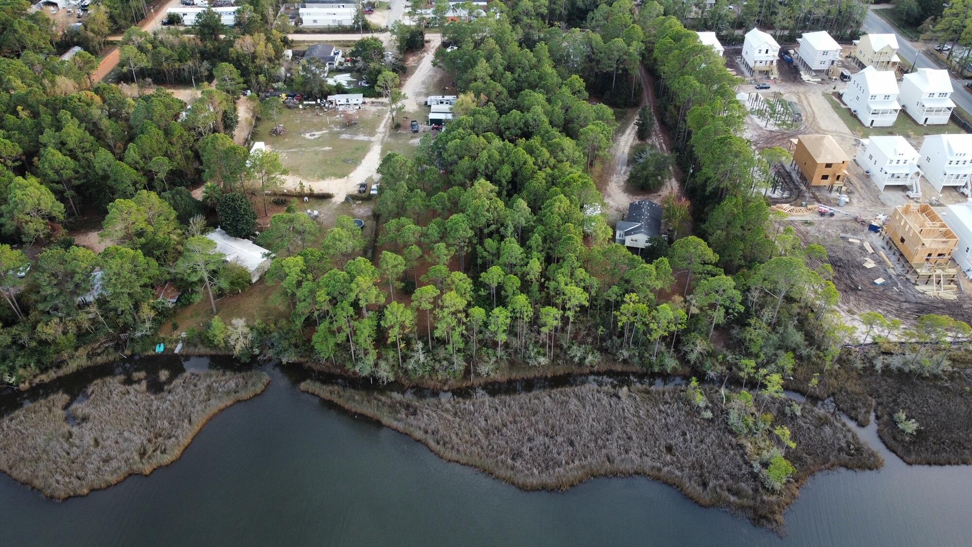 This is a Developer's or Builder's dream. Over 1 acre of assembled land consists of 6 county platted homesites + vacated alley between 2nd tier lots +water frontage parcel of 90 feet with Bay or Bayou Views! Waterfront Park and Boat Dock at Cessna Park just across the street. Pull permits and build now or later on platted lots. you could also Create your own subdivision with waterfront community feature.Buyer to verify all dimensions. Some of the photos are of homes being built next door in Cessna Landings for sample building on pilings. Also photos of near by launch and park across HWY 331.