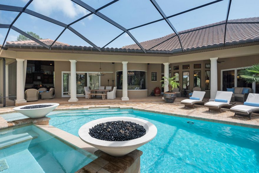 The warmth of a European estate is combined with impeccable amenities in this villa nestled on a private lot in the prestigious gated neighborhood of The Preserve at Burnt Pine. The screened lanai hosts a heated pool with waterfall feature flanked by fire bowls, multiple gathering areas and a Summer Kitchen with gas fireplace, television, grill and granite bar for savoring the flavors of the season. The open concept living area flows effortlessly from casual dining room to sweeping family room with stackable floor to ceiling glass doors. The epicurean kitchen welcomes you with a six burner gas stove, hammered copper galley sink and Thermador dual refrigerators. The master suite offers the ultimate in luxury with a morning kitchen including Miele Coffee Bar, dual sitting areas and expansive