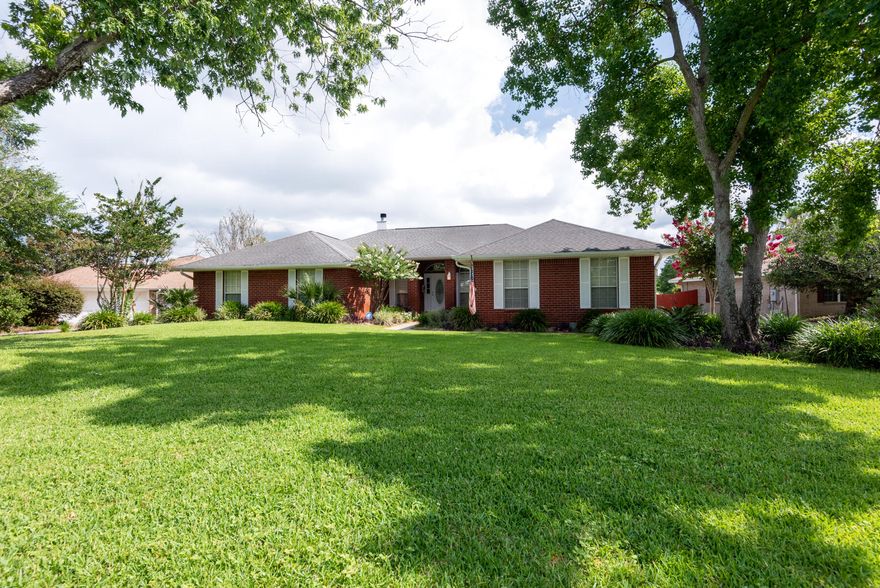 With an acceptable offer, the sellers will replace the roof. The home has a transferable warranty through Old Republic which also covers the pool and septic system. Experience your own piece of paradise in this must-see contemporary brick, lakefront pool home in the desirable subdivision of Spanish Trace Estates. As you walk into the open foyer, you'll notice hardwood and tile floors in the main living areas and French doors entering into the home office. The open large great room has high cathedral ceilings, a fireplace and French doors leading you to the screened in gunite pool with views of the lake. The patio has an expansive paver deck and covered seating area for all your guests.