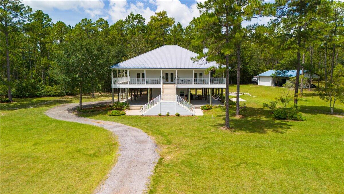 Southern Farmhouse on 5 Acres!This beautifully remodeled 4BR/3BA + office retreat blends Southern charm with modern upgrades--just 17 mins to Freeport and 35 mins to 30A & Panama City Beach. Inside, enjoy fresh paint, updated baths, vaulted ceilings, and French doors from every bedroom opening to a wraparound porch. The primary suite features a private screened porch. Outside, the fully fenced 5 acres include power & water along fence perimeter, a spring-fed creek, pond, no HOA, and ample space for animals. A 1,200 lb freight elevator, powered workshop w/ garage & carport, and a new high-efficiency well add function. Plus, the concrete pad is hot tub or swim spa-ready! Flood Zone X for the home, clean landscaping. Low-maintenance living--move-in ready and full of potential, see it today!
