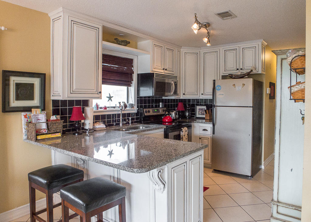 Great price on this 3-bedroom, 2-bath Seagrove Beach condo, along Scenic Hwy 30A. This 3rd floor end unit is incredibly private and has a peak of the gulf. This condo is being sold fully furnished with great decor. Unit has been UPDATED with CUSTOM kitchen cabinets and granite countertops. It is in excellent condition, with tile throughout, NEW carpet in the bedrooms, NEW sofa and chairs, NEW toilets, built-ins in the master closet, new fridge, NEW bunk beds and NEW patio furniture. Spacious covered porch allows for that outdoor living and views of one of the pools. Condo also has a separate laundry room inside the unit. Beachwood Villas is a family oriented community with 2 pools (1 heated), lighted tennis courts, children's fenced in play area, grilling areas and shuffleboard. Publix i