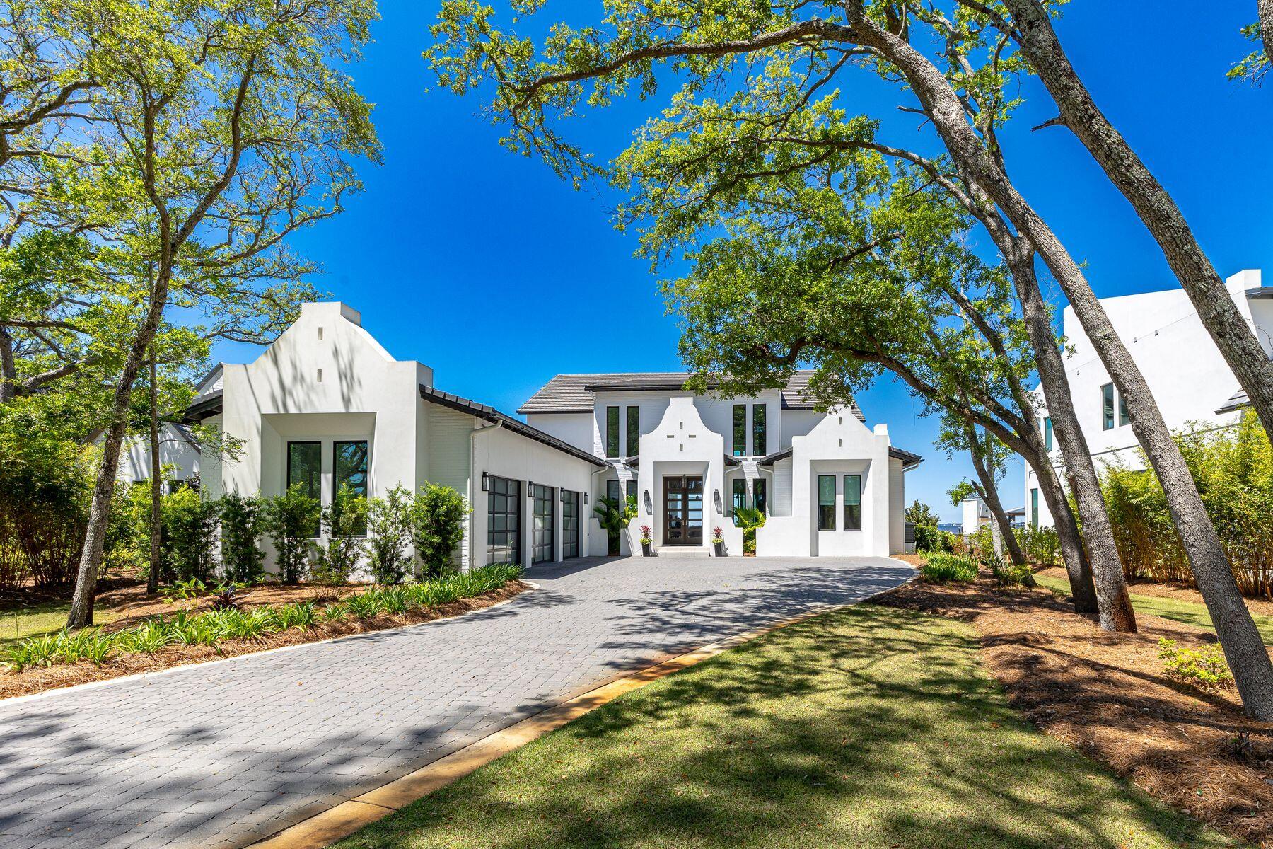 This extraordinary coastal estate is a legacy property sitting on almost an acre with 100 feet of prime waterfront on Choctawhatchee Bay. Boasting amazing year-round sunset views, it has a private pool, dock, and boat slip with lift. This outstanding residence is perfect for hosting lavish parties and entertaining on a grand scale. Built in 2021, it has an elegant white stucco and painted brick exterior. Step through the door to find a breathtaking open floor plan with 23-ft. ceilings and an upper mezzanine. Two stories of floor-to-ceiling glass frame breathtaking bay and sky views while fully retractable doors seamlessly connect the great room with the outdoor lanai. An impressive two-story fireplace emphasizes the visual impact of this soaring space. Reclaimed barn-wood flooring enhance