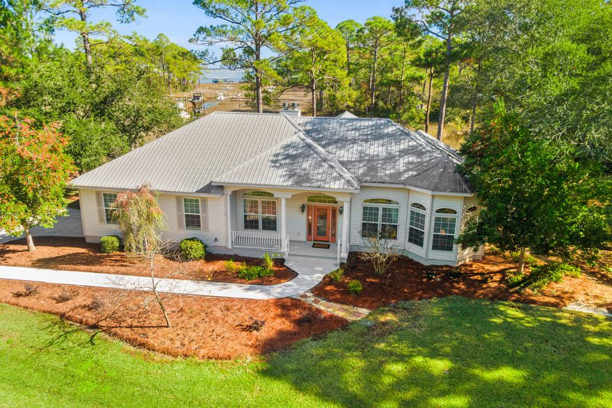 A refined waterfront estate on two lots spanning 325 feet road frontage, this exceptional 1.2-acre property is located within an intimate, HOA-protected bayfront enclave. The property features 230 feet of navigable waterfront on Gurley Creek, with unobstructed views across a federally protected estuary to Choctawhatchee Bay, preserving the natural setting for generations. The custom-designed residence, built in 2005 and held by the original owner, has been well maintained and thoughtfully updated. The home offers three bedrooms and two baths with comfortable, elegantly designed living spaces featuring scenic vistas through many large windows and French doors in every room. Additional highlights include a 40-year steel roof and an oversized garage. A rear covered screened porch provides a peaceful extension of the living area ideal for enjoying coastal breezes, water views, and quiet evenings overlooking the Creek and Choctawhatchee Bay. A private, custom-built boat dock located on a natural slip provides direct access to 230 feet of navigable waterfront, allowing easy passage to Gurley Creek and onward to Choctawhatchee Bay for boating, paddleboarding, and fishing. Situated within a 31-home single-family bayfront community with very low annual HOA dues, this property blends privacy with long-term protection. Ideally located just three miles from the white-sand beaches of the Gulf of Mexico, as well as shopping, dining, and medical facilities. An elegant, well-kept waterfront retreat where scale, views, and location converge in a truly special coastal setting.

